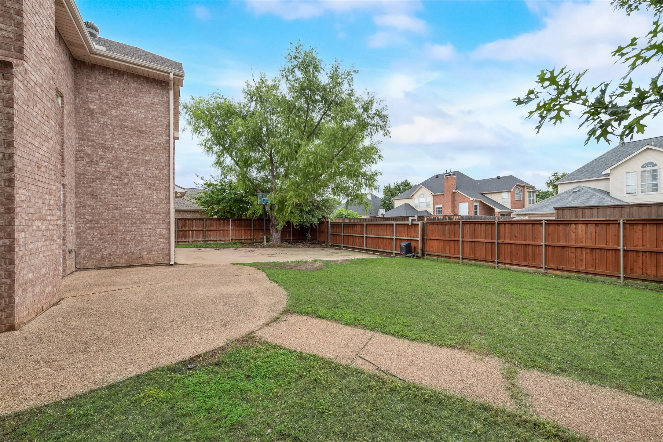 Expansive backyard featuring a manicured lawn, a gravel pathway, and a large gravel patio