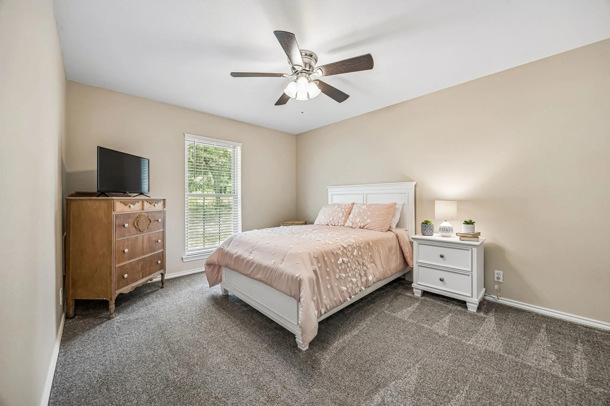 Nice size split secondary bedroom with ceiling fan and carpet.