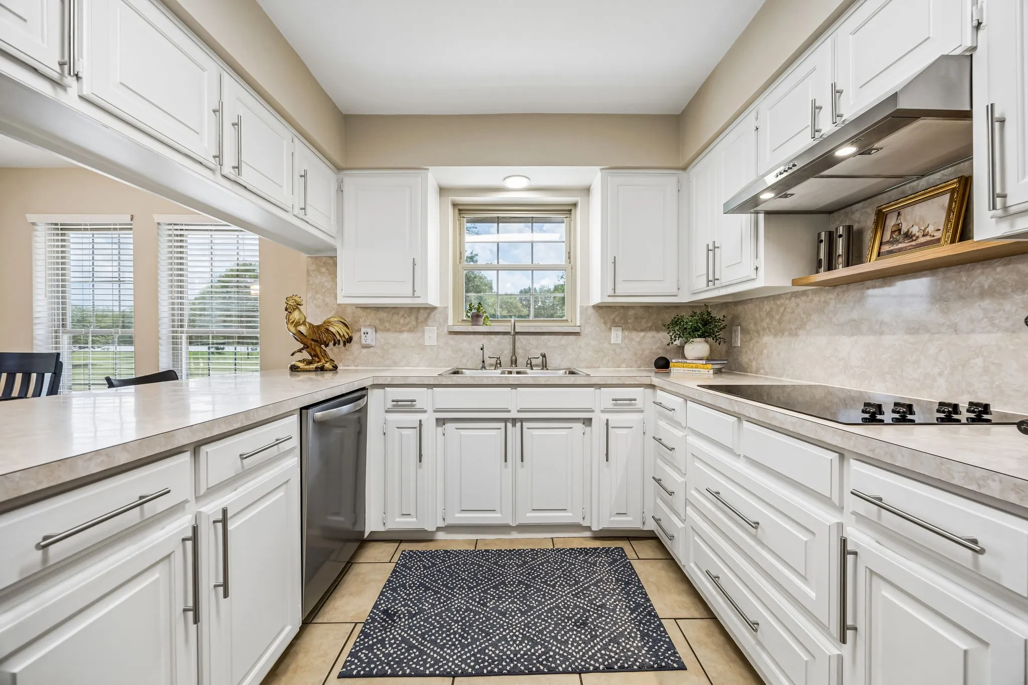 The kitchen offers freshly painted cabinetry with new hardware, flat surface cooktop and a window over the sink providing great natural light and views of the front yard.