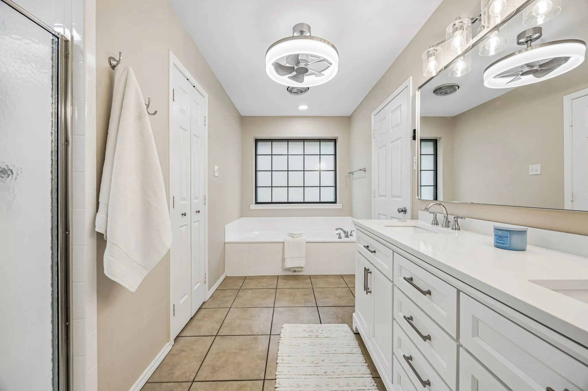 The primary bath enjoys a low profile ceiling fan with light, frosted window and soaking tub.