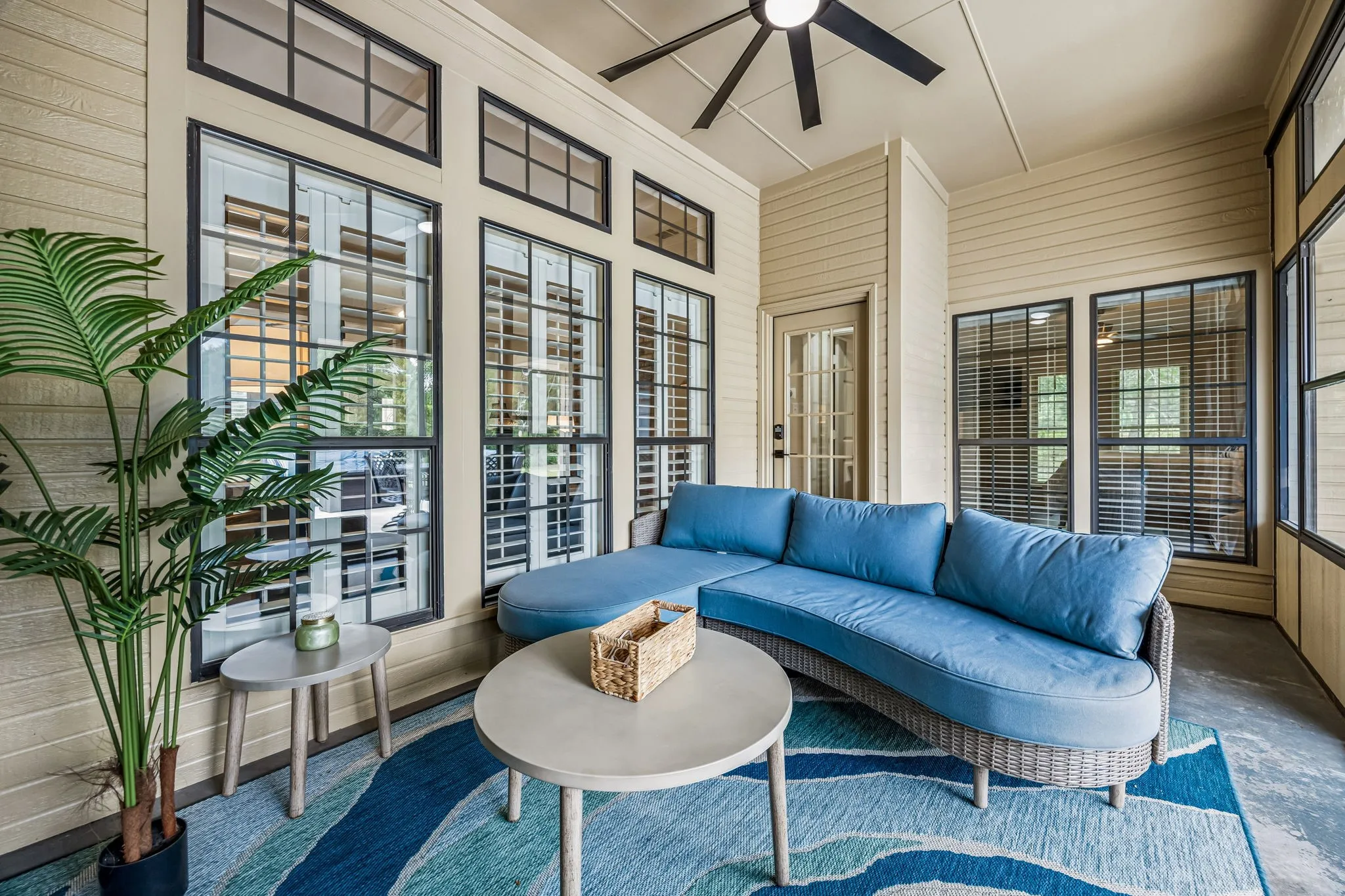 The sunroom is off the living room and the primary bedroom. Large ceiling fan cools the air.