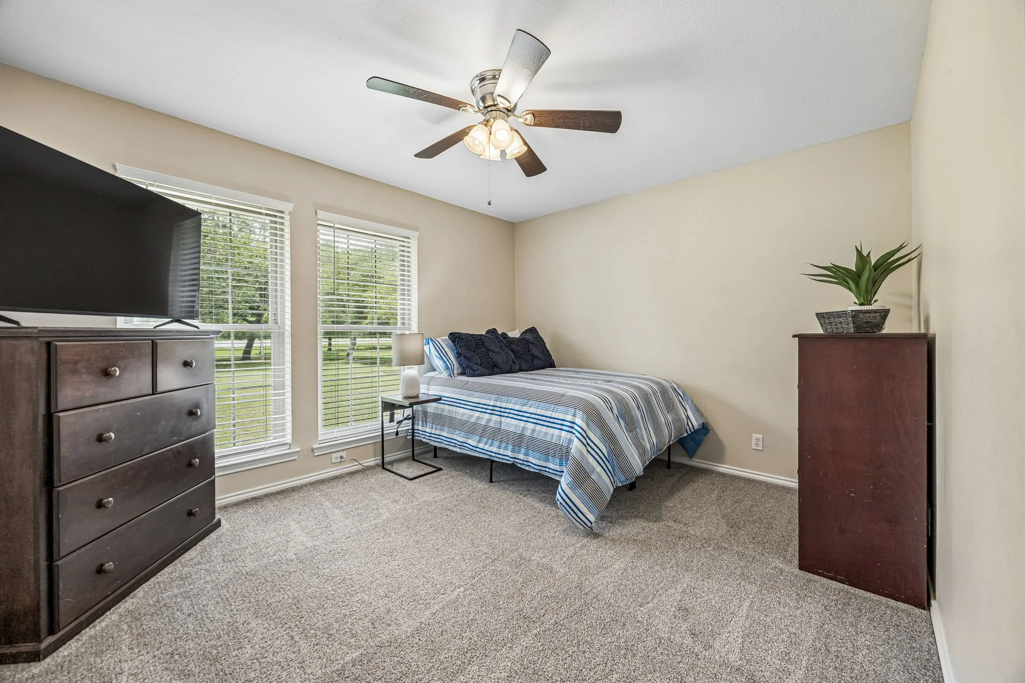 Nice size split secondary bedroom with ceiling fan and carpet.