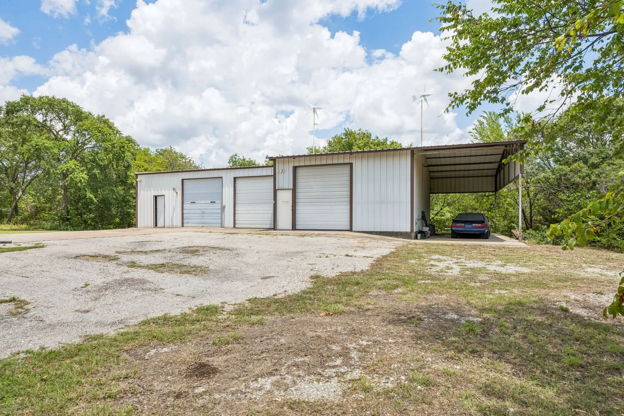 Looking toward the outbuildings behind the home. The carport could serve as an RV pad.