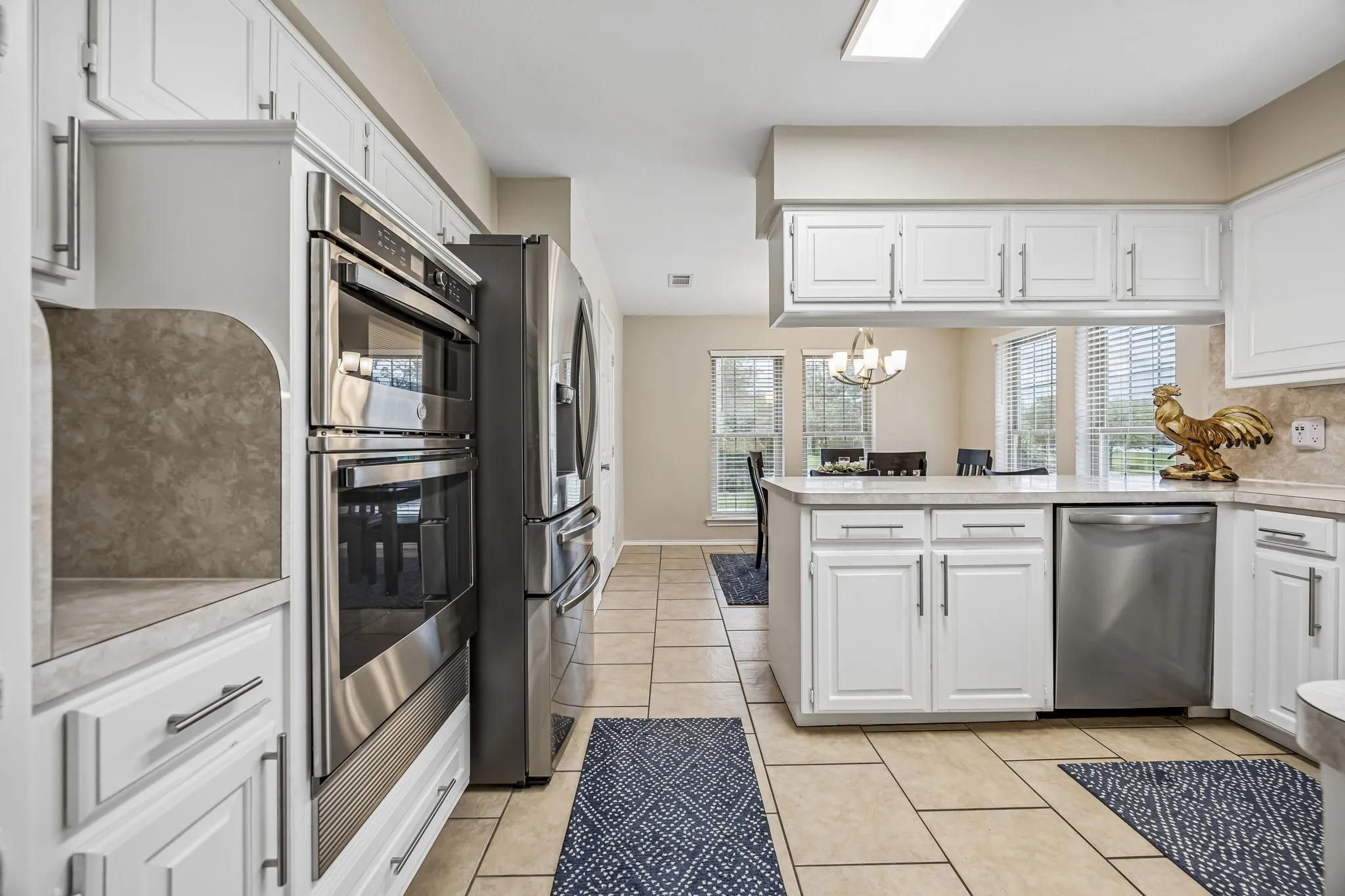 Kitchen boasts stainless steel appliances including new microwave-oven set up. The peninsula provides space for a pass through buffet or extra seating.