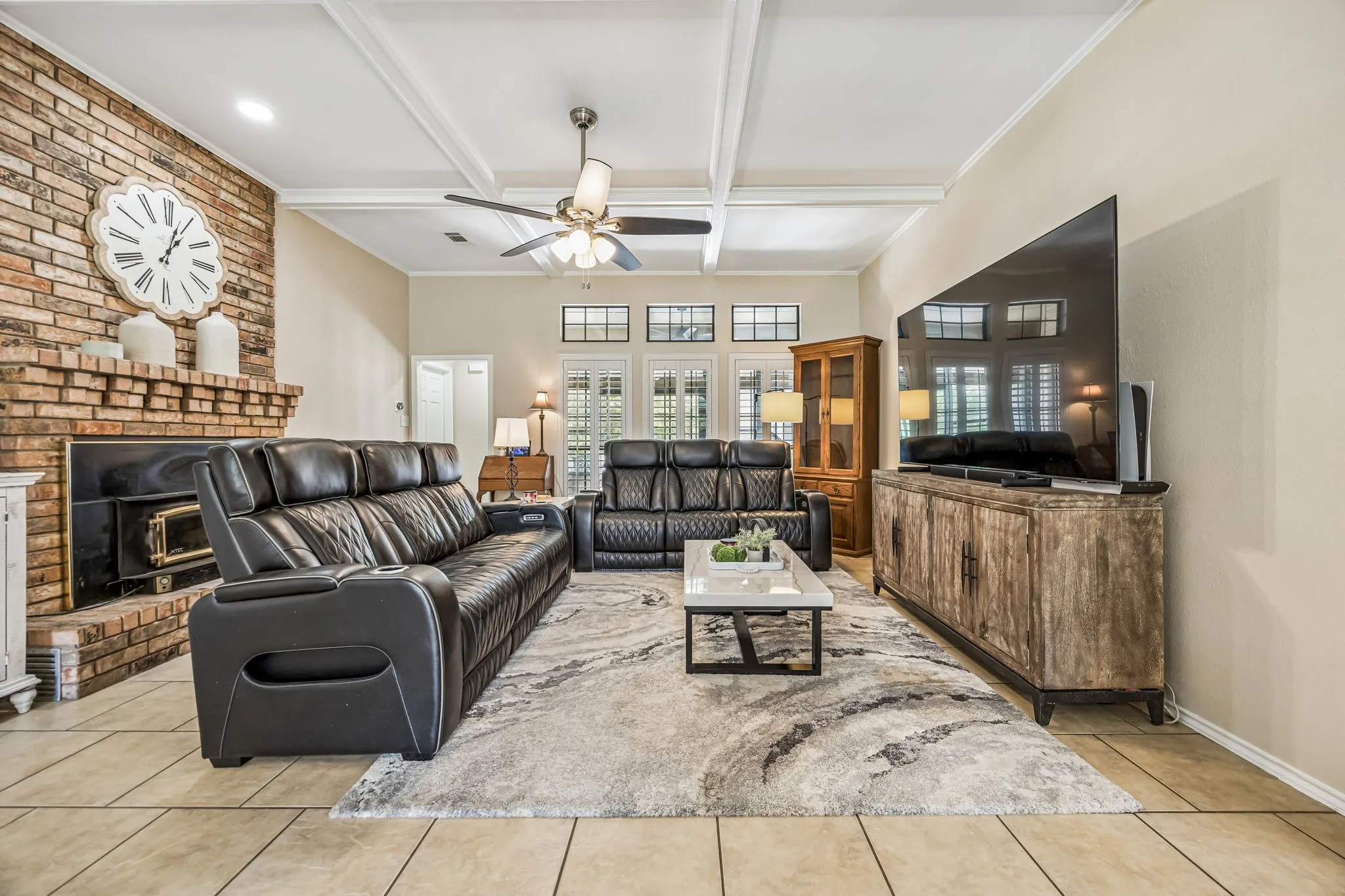 The spacious living room is anchored by a brick, wood burning stove and enjoys views of the back of the property.