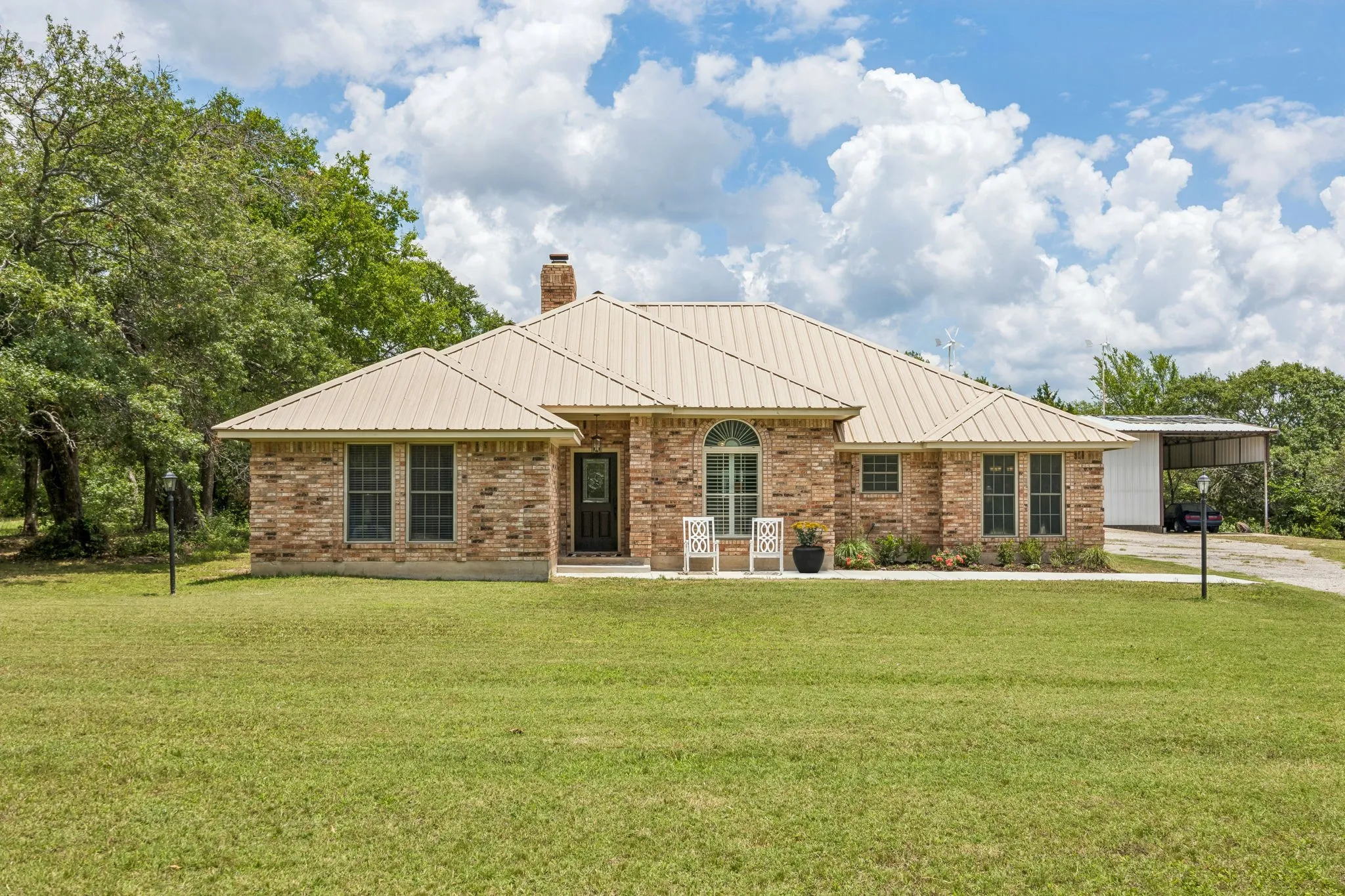 Home sweet home in this beautiful brick with metal roof home! Landscaped flower beds and patio that's perfect for enjoying your morning coffee complete the charming drive up appeal.