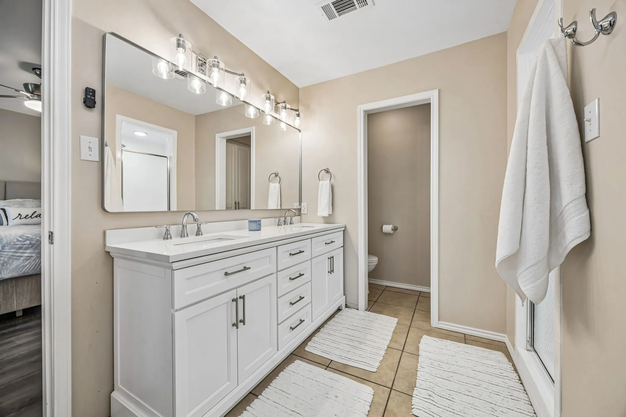 The updated primary bath has new vanity with quartz countertops with wave sinks and brushed nickel fixtures. The modern framed mirror and updated light fixtures complete the look!