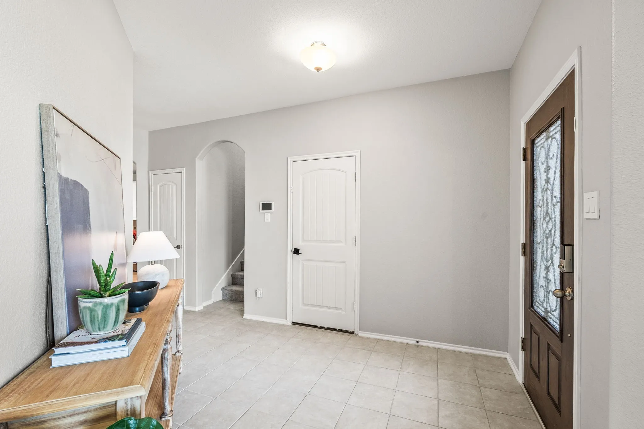 Foyer featuring light gray walls and square tile flooring