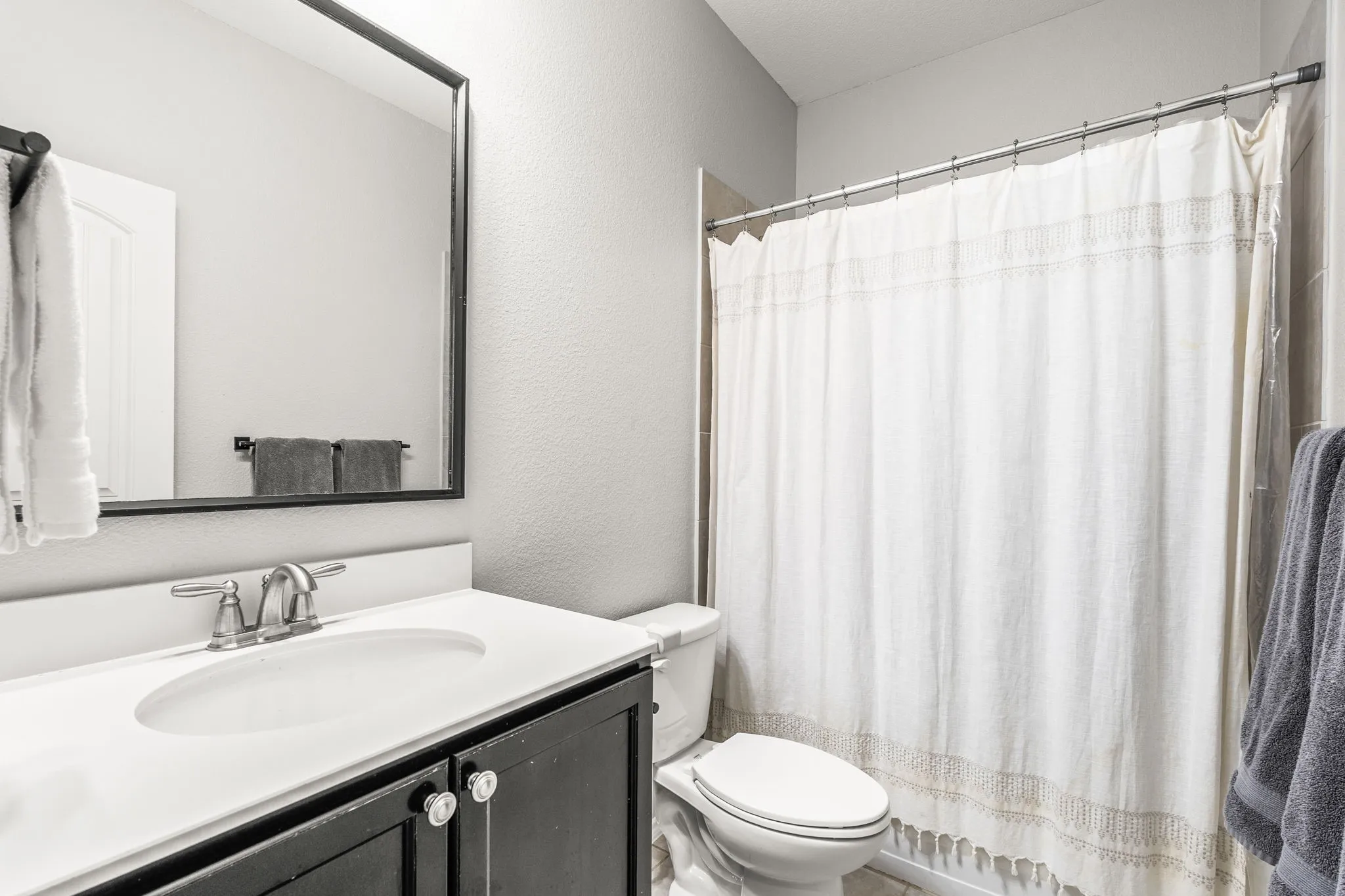 Bathroom featuring a vanity with a dark wood-finish cabinet, white countertop, and integrated sink
