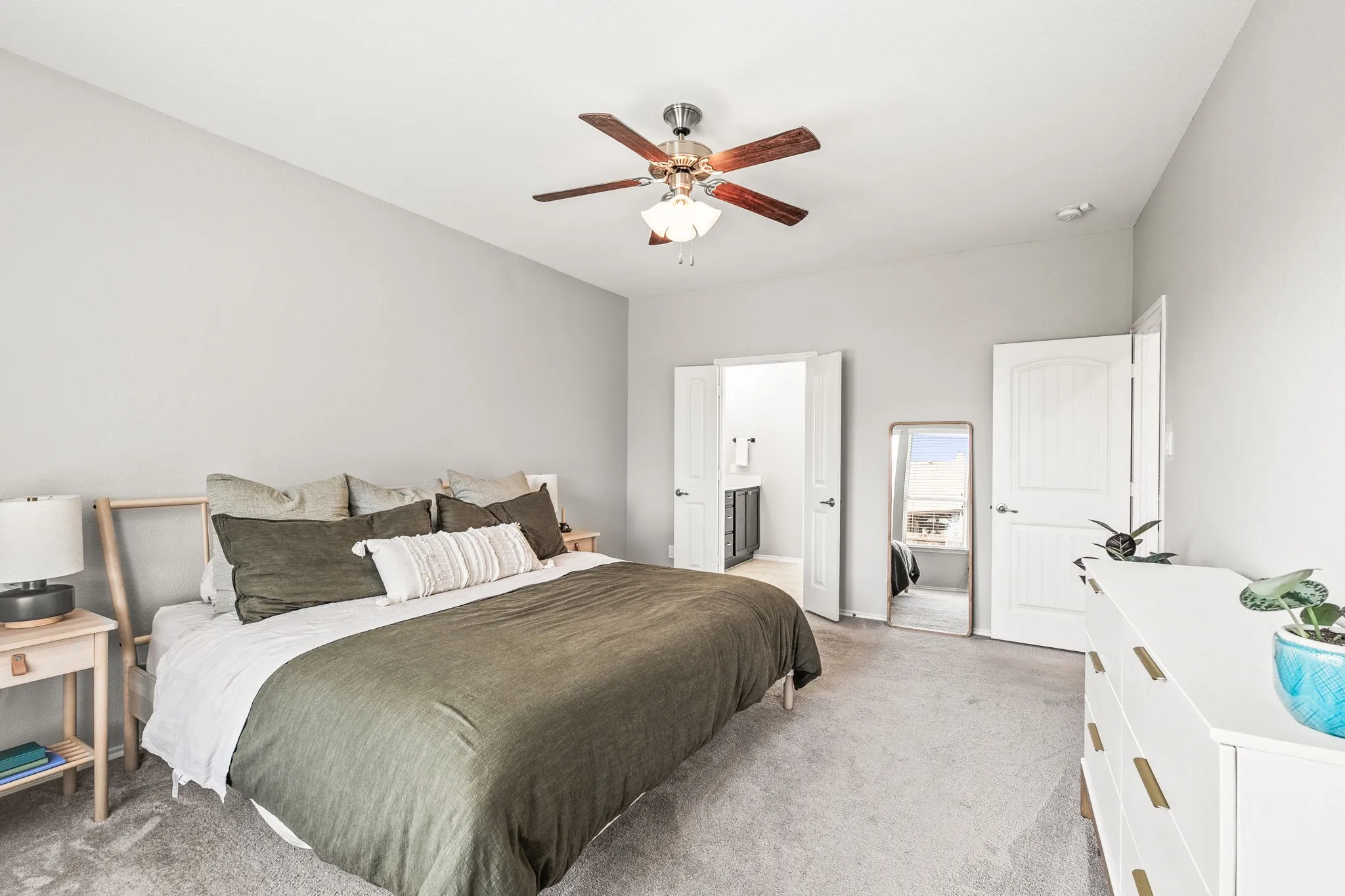 Spacious room featuring vaulted ceilings, light gray wall paint, and plush carpeting
