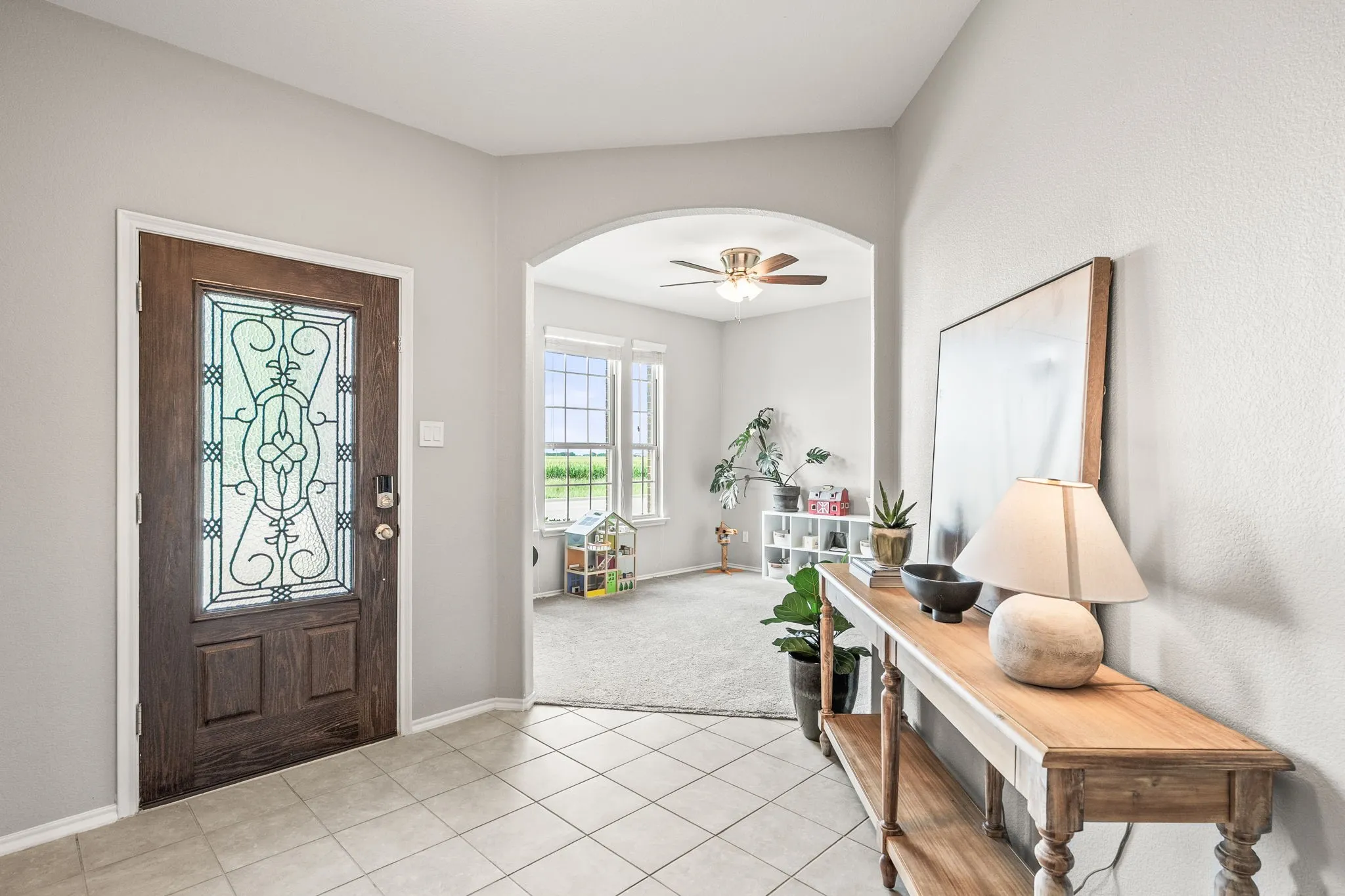 Entryway featuring a dark wood front door with decorative glass, tile flooring, and light gray walls