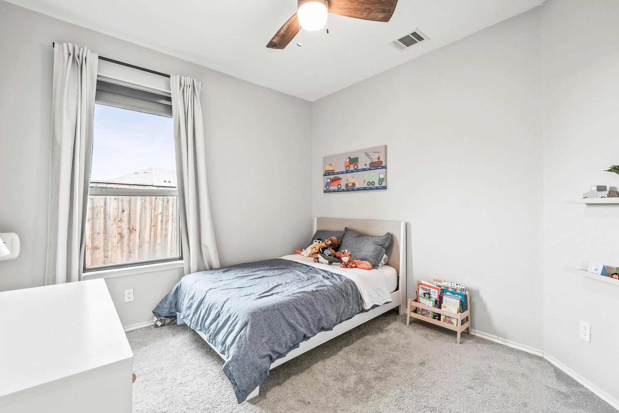 Carpeted room featuring a single window with blinds and curtains, a ceiling fan with light, and light gray wall paint