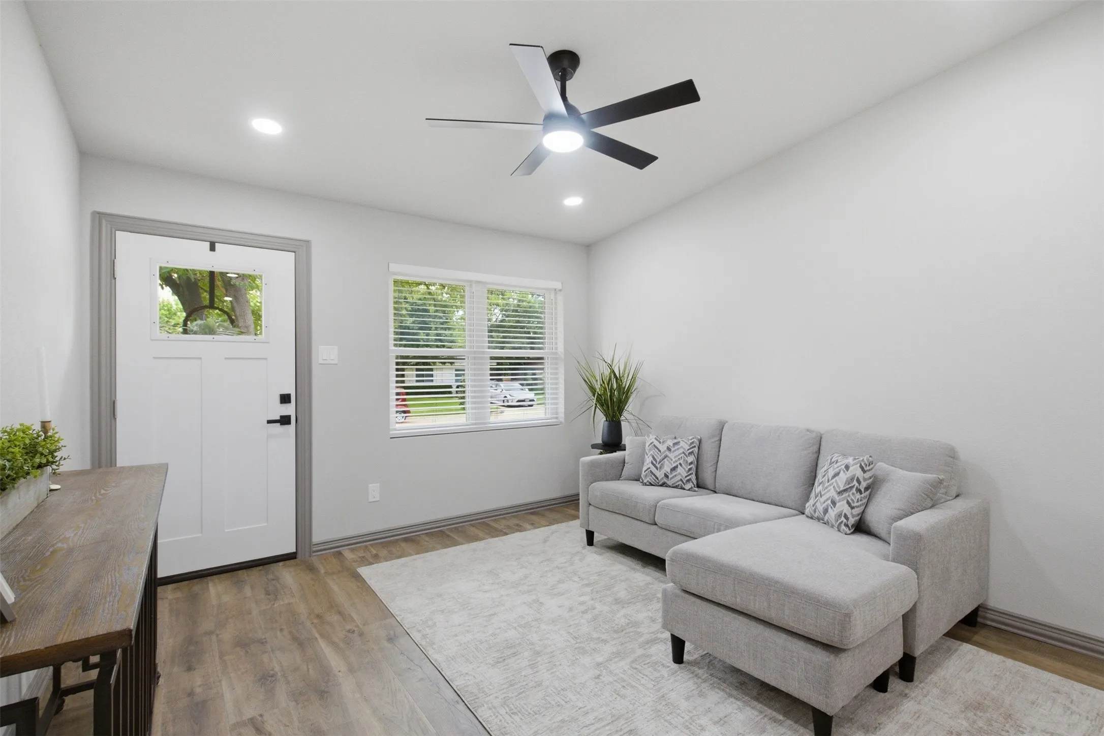 Open-concept living area featuring wood-finish flooring, recessed lighting, and a ceiling fan