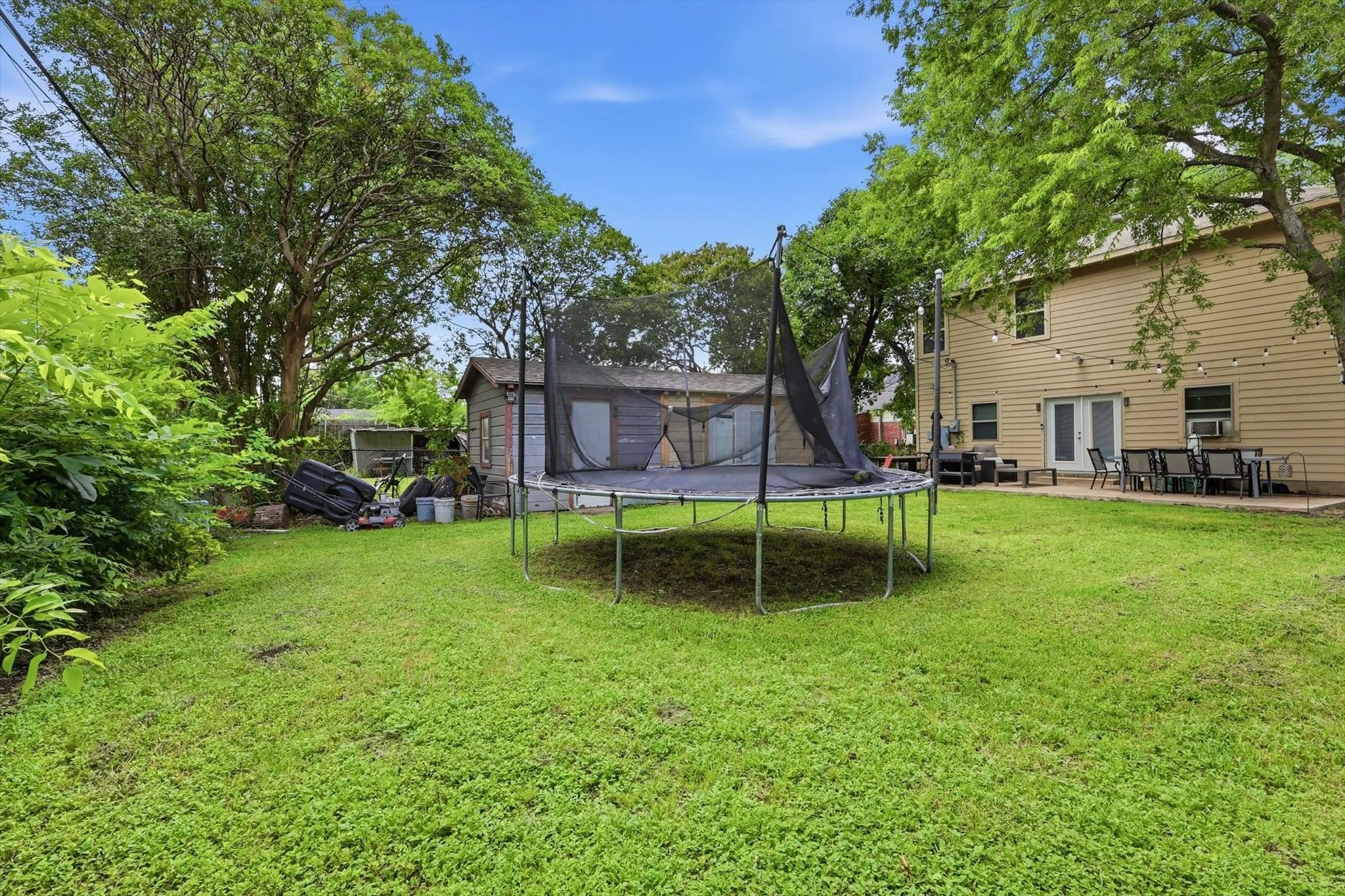Expansive green lawn with mature trees bordering the property