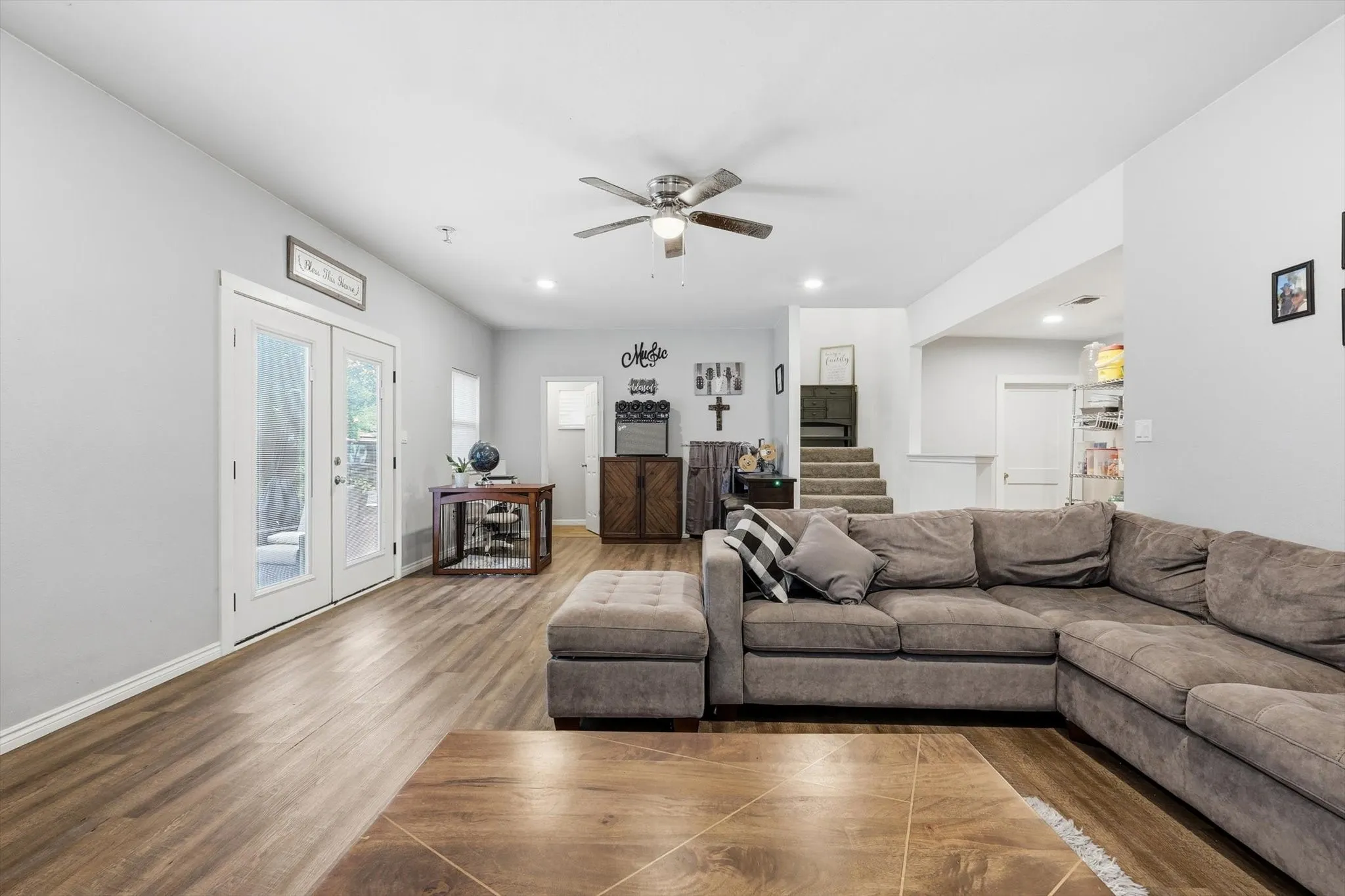 Spacious living area featuring wood-finish flooring, recessed lighting, and a ceiling fan