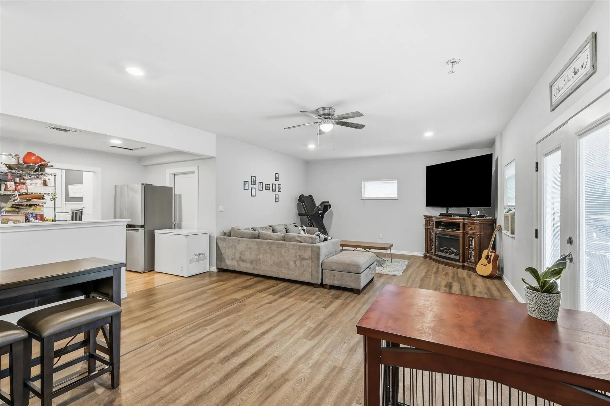 Open-concept living area featuring wood-finish flooring, recessed lighting, and a ceiling fan