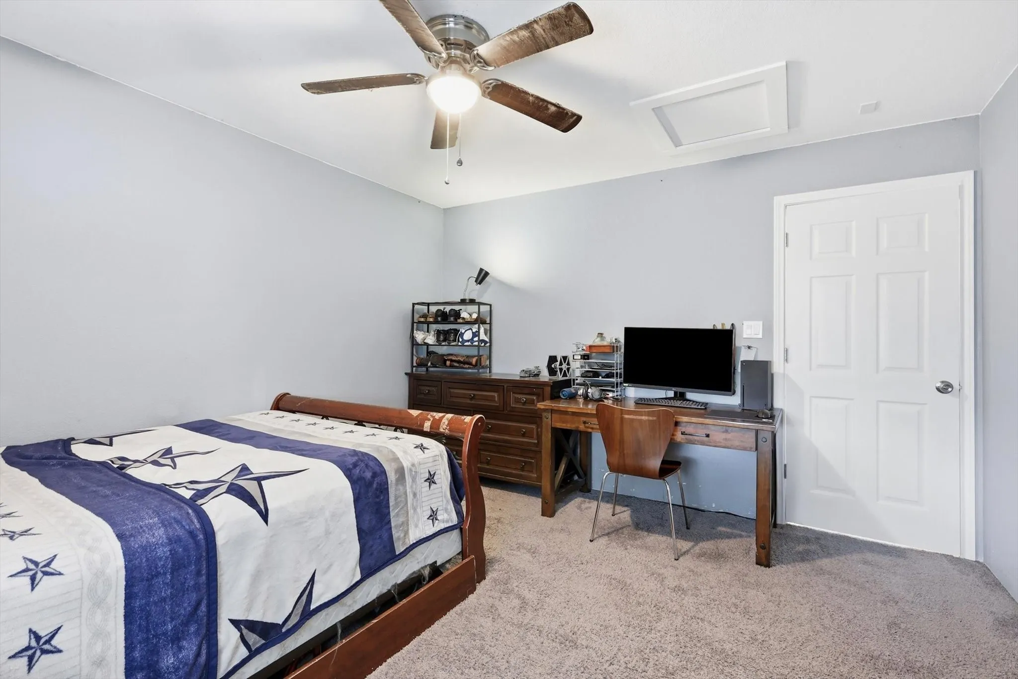 Carpeted room featuring a ceiling fan with integrated lighting, a white paneled door, and light-colored walls