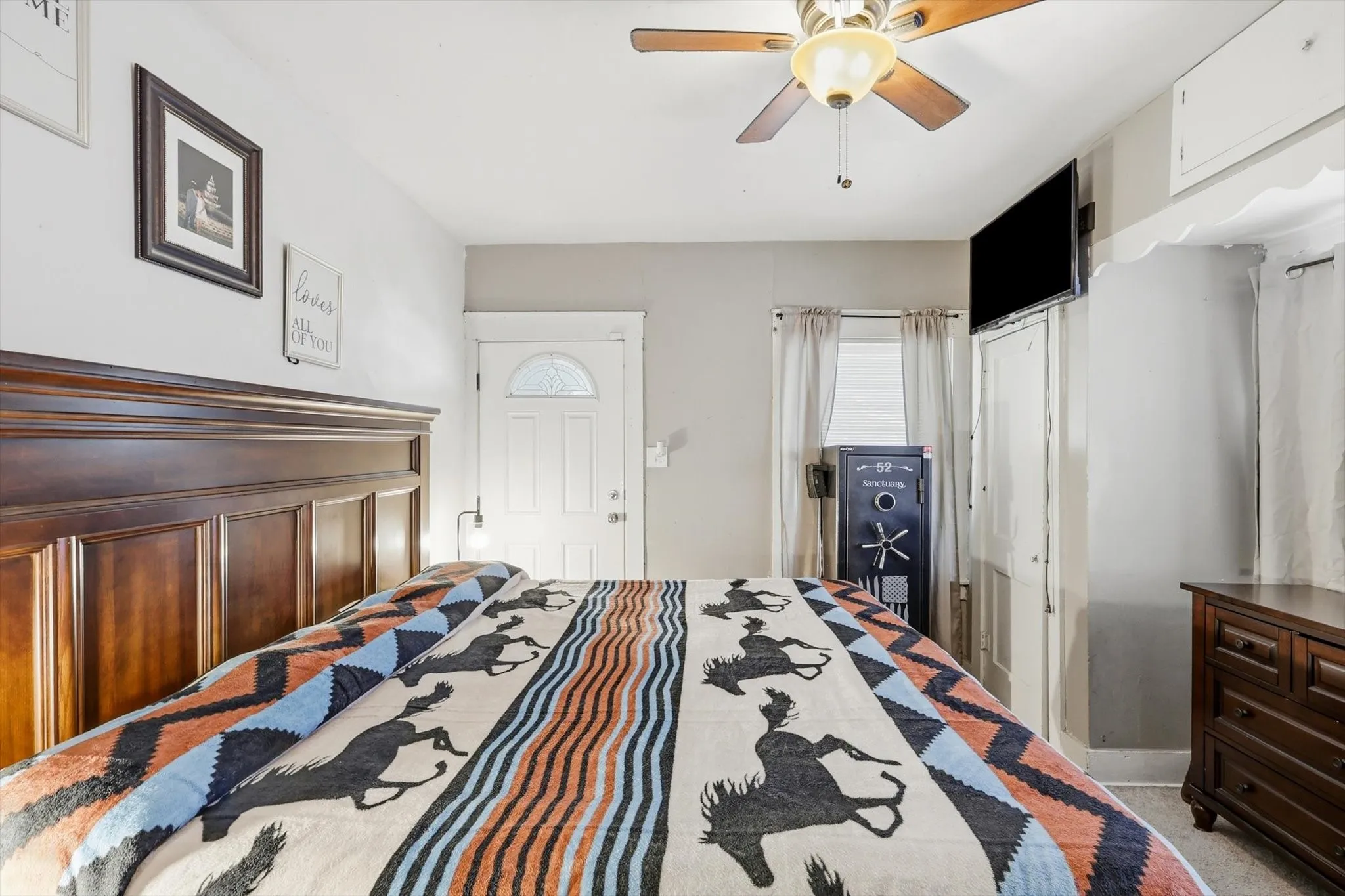 Wood-finish paneled headboard with an adjacent white door featuring a decorative arched glass insert