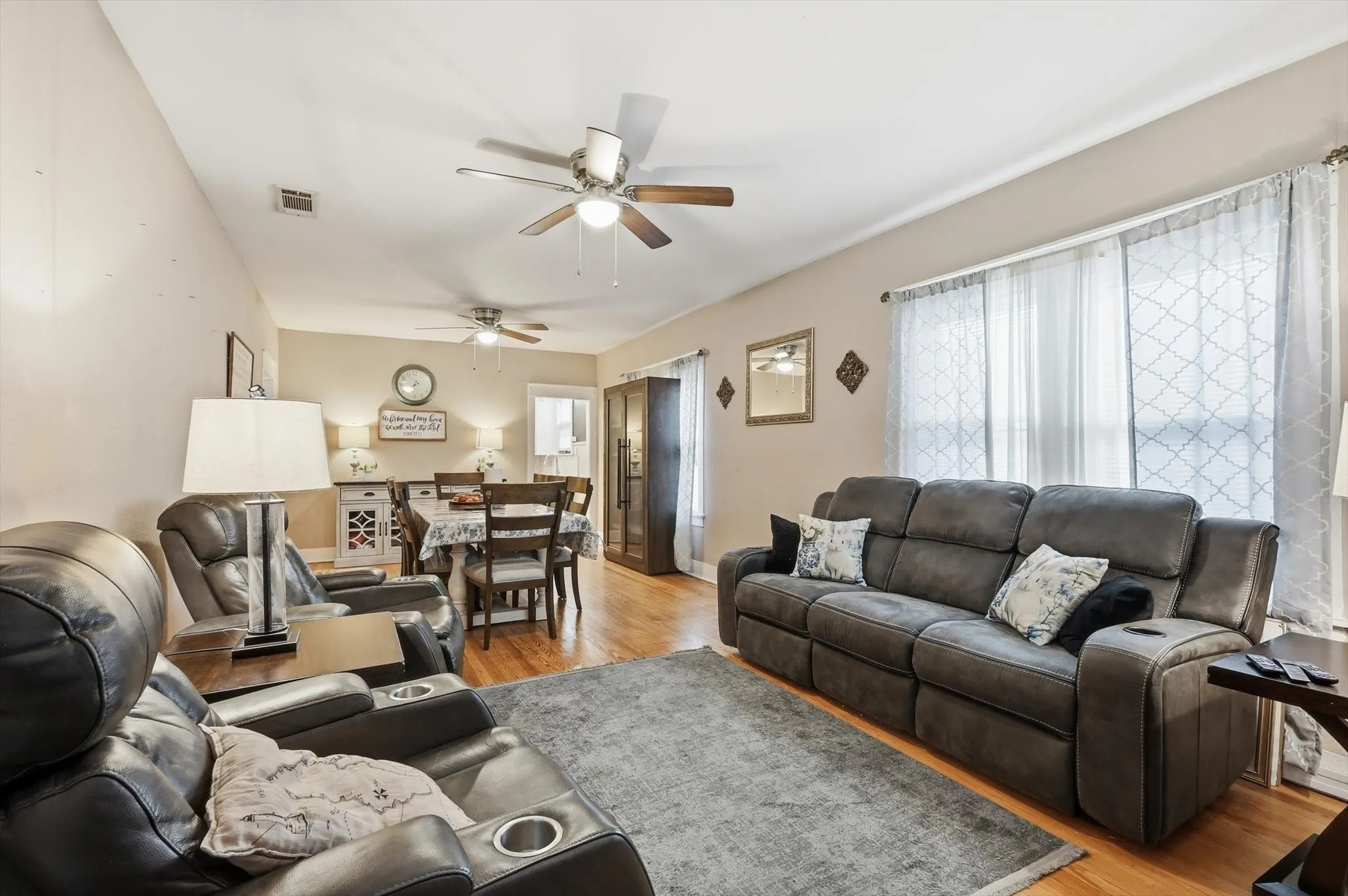 Open-concept living area featuring wood-finish flooring, neutral wall tones, and recessed lighting