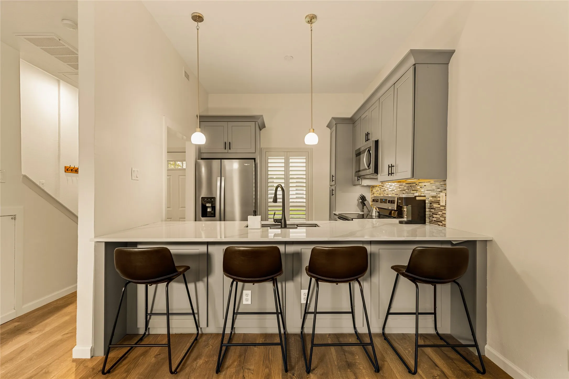 Quartz countertops and custom cabinetry create a timeless aesthetic.