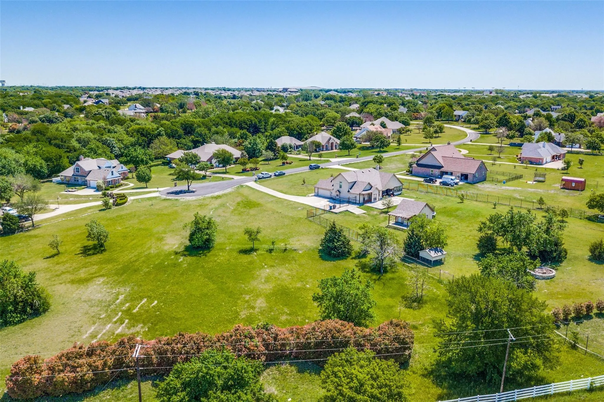 Expansive green spaces define this residential setting, featuring mature trees and established landscaping