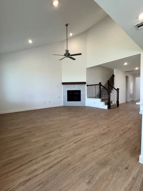 Vaulted ceiling living space with wood-finish flooring