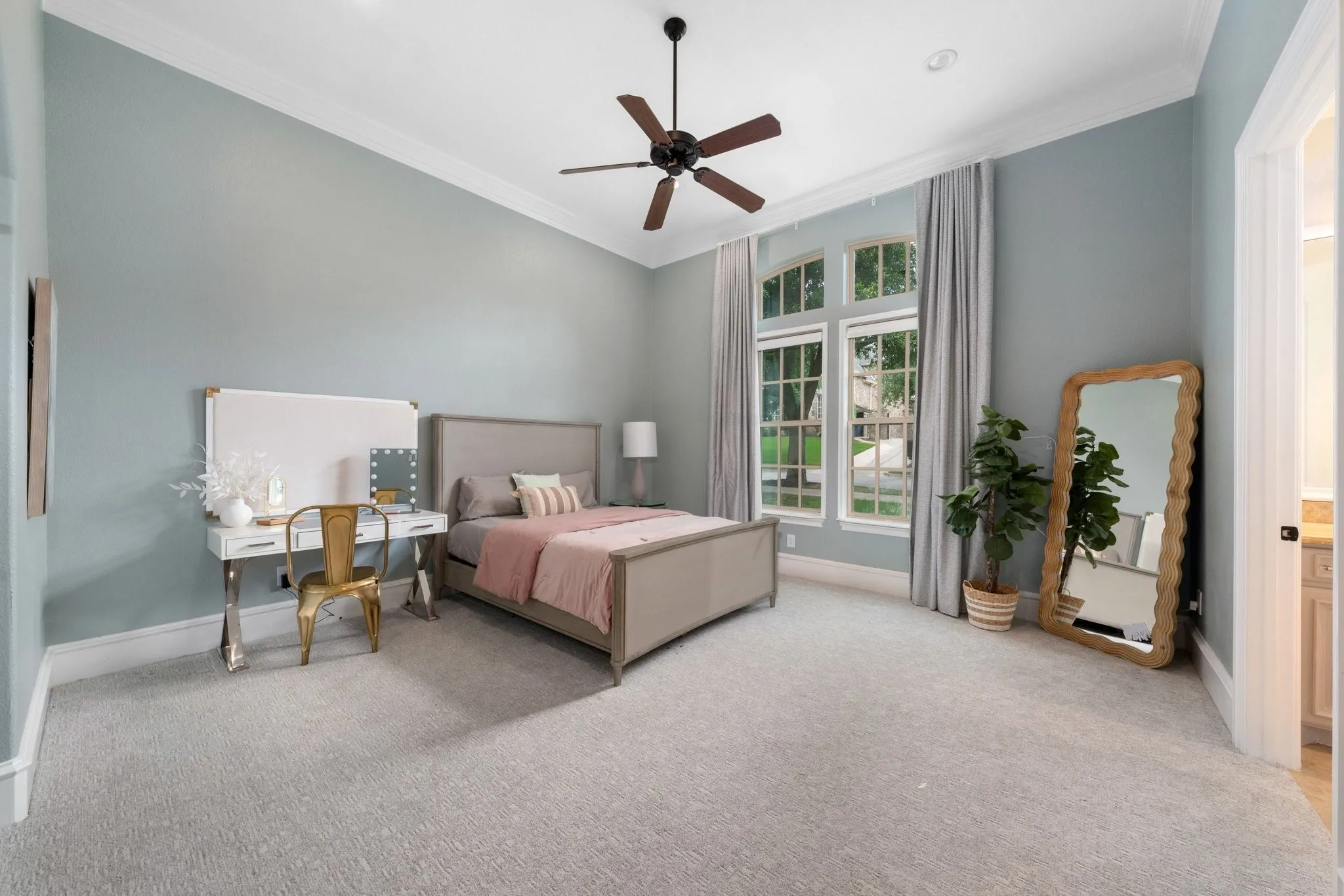 Expansive room featuring high ceilings, light-colored carpeting, and a multi-pane arched window with drapes