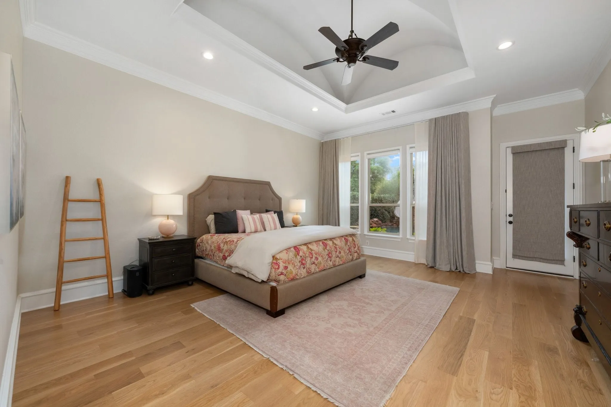 Spacious room featuring a tray ceiling with a ceiling fan, recessed lighting, and crown molding