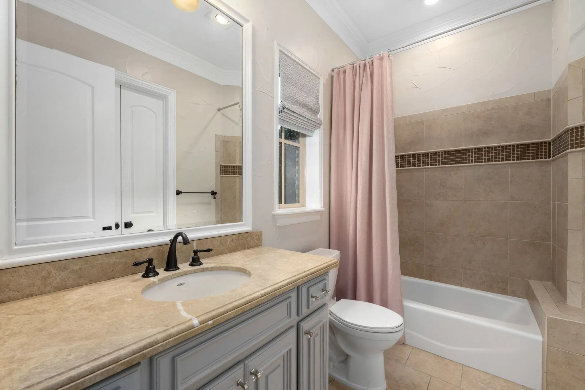 Bathroom featuring a vanity, stone countertop with an undermount sink, and dark bronze hardware