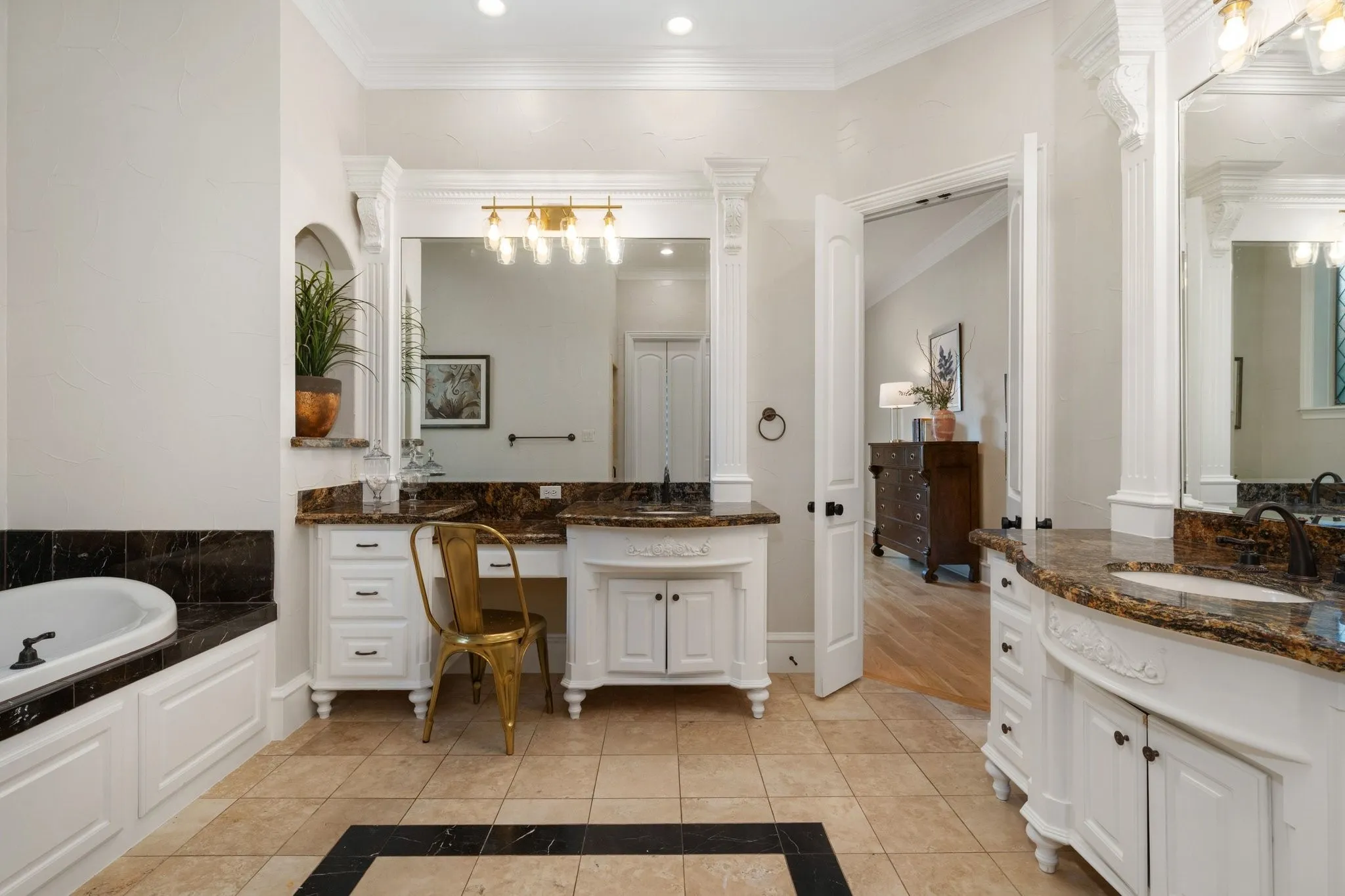 Spacious bathroom with dual vanity areas featuring integrated sinks and stone countertops