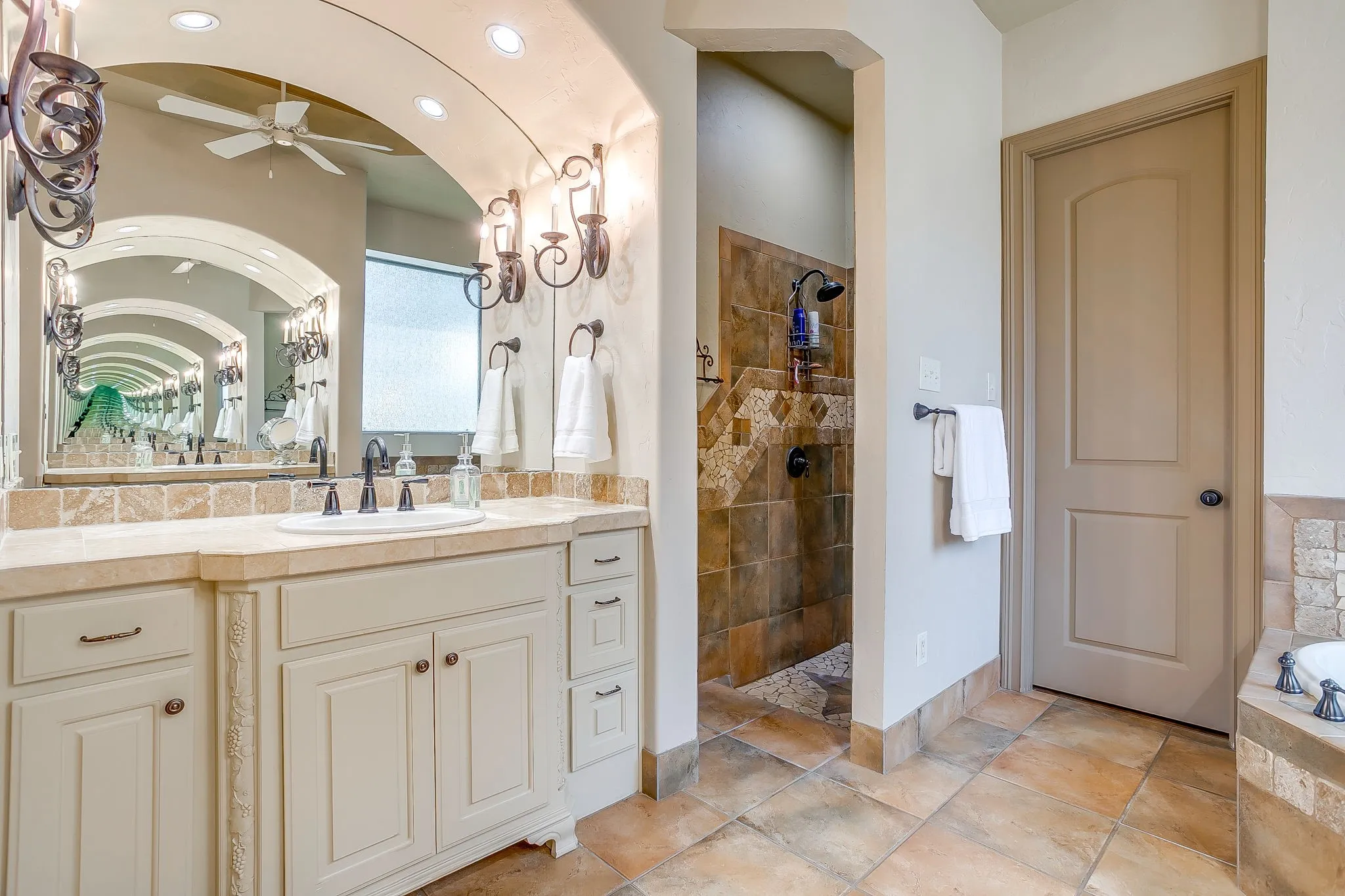 Bathroom vanity with an integrated sink, dark bronze faucet, and sconce lighting