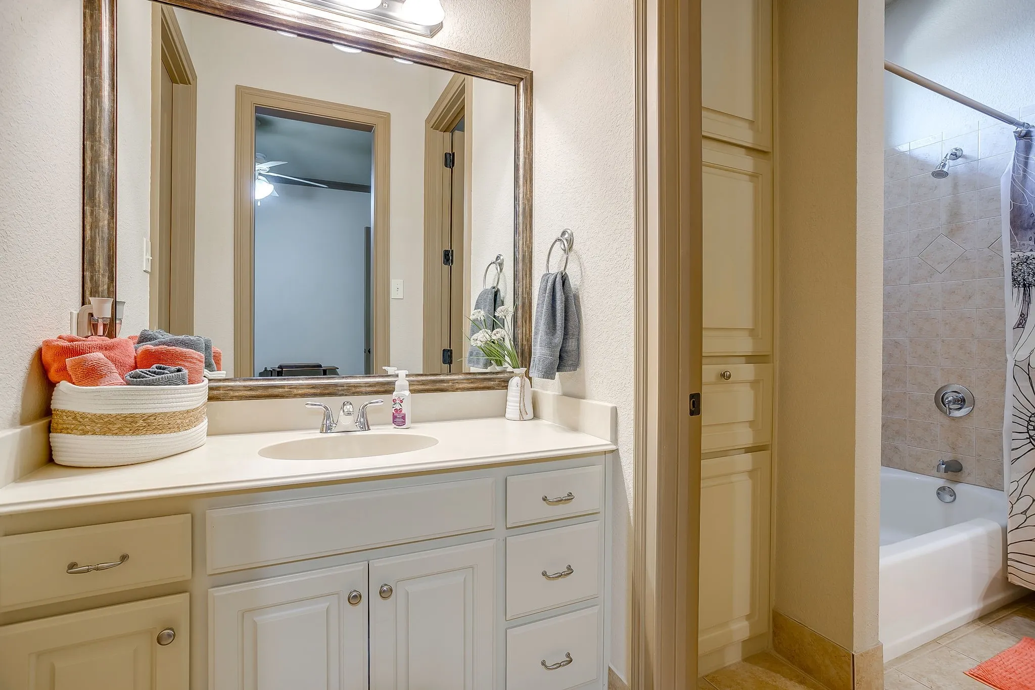 Bathroom featuring a single vanity with an integrated sink, white cabinetry, and brushed nickel hardware