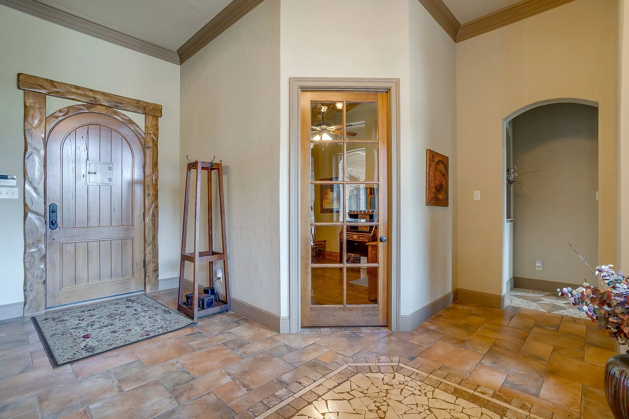 Arched wooden entry door with carved surround