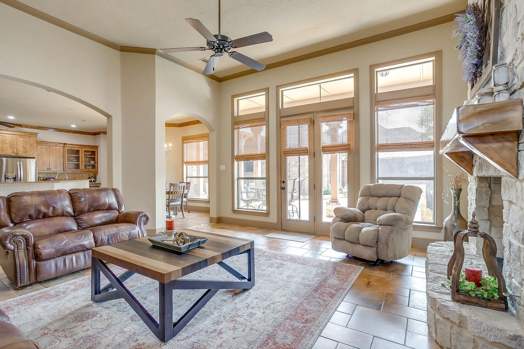 Spacious living area featuring high ceilings with a ceiling fan, tile flooring, and French doors