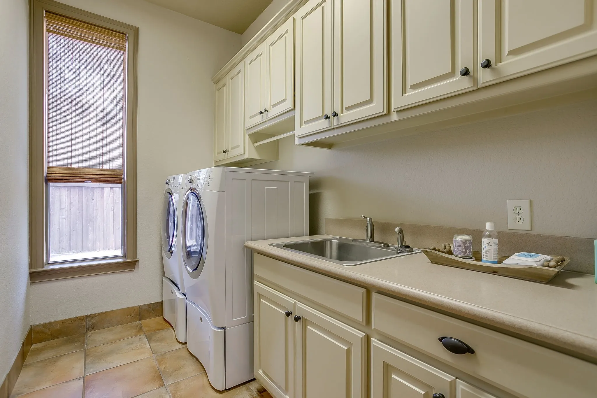 Dedicated utility space featuring extensive cabinetry, a built-in sink, and generous countertop area