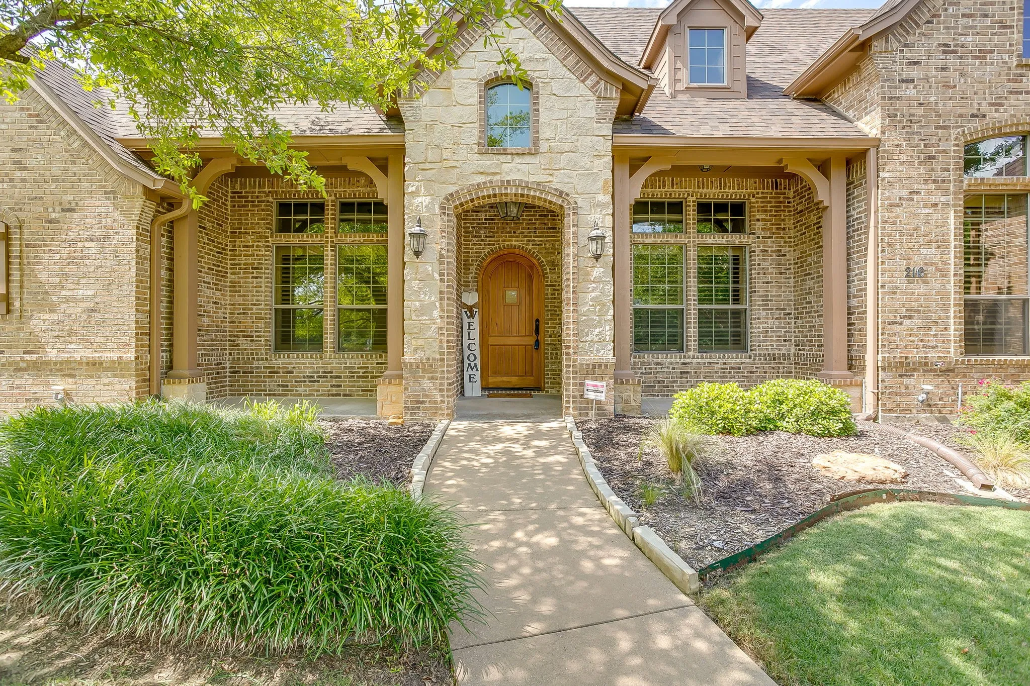 Brick and stone facade featuring an arched entryway