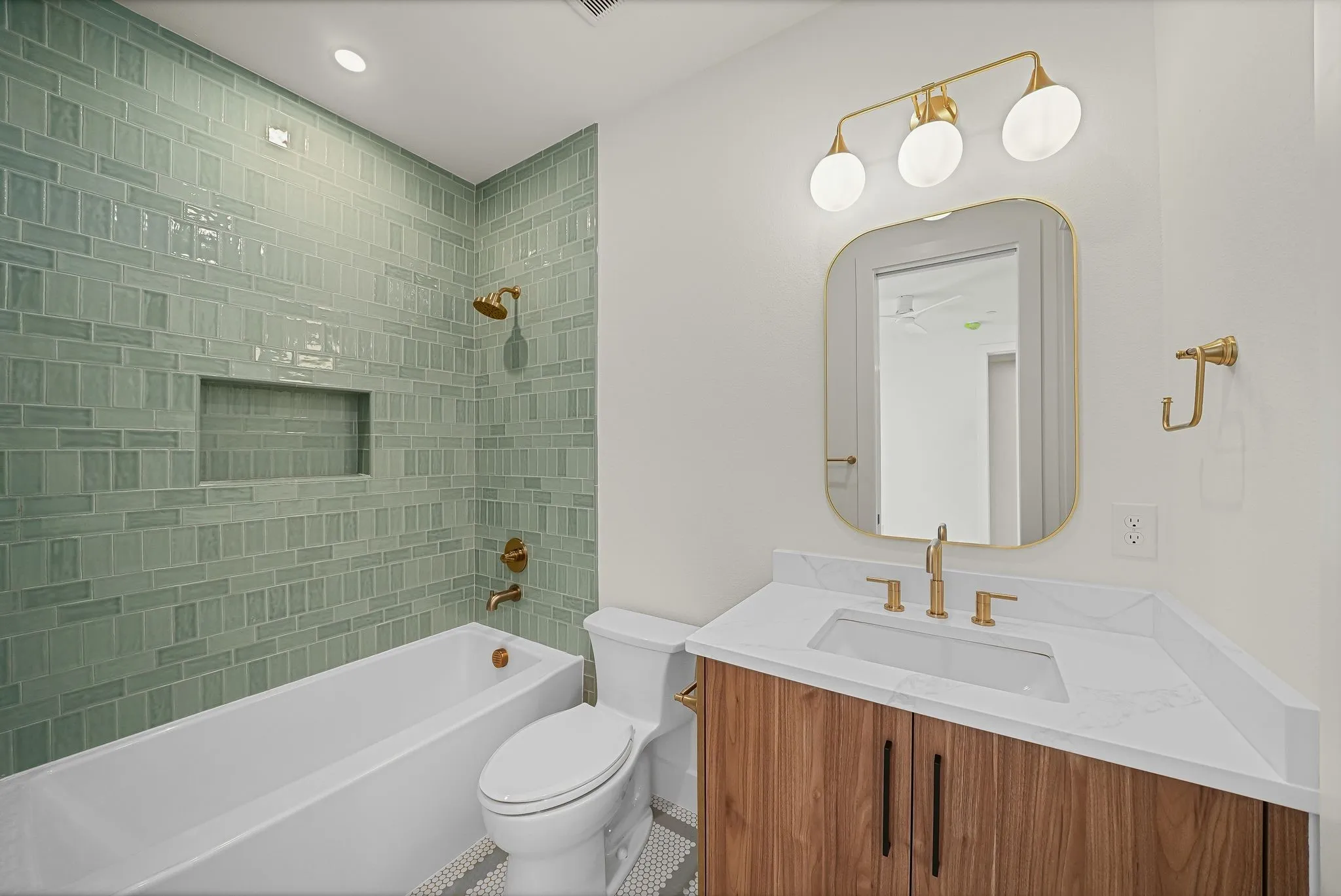 Bathroom featuring a tub/shower combination with green subway tile surround and integrated niche