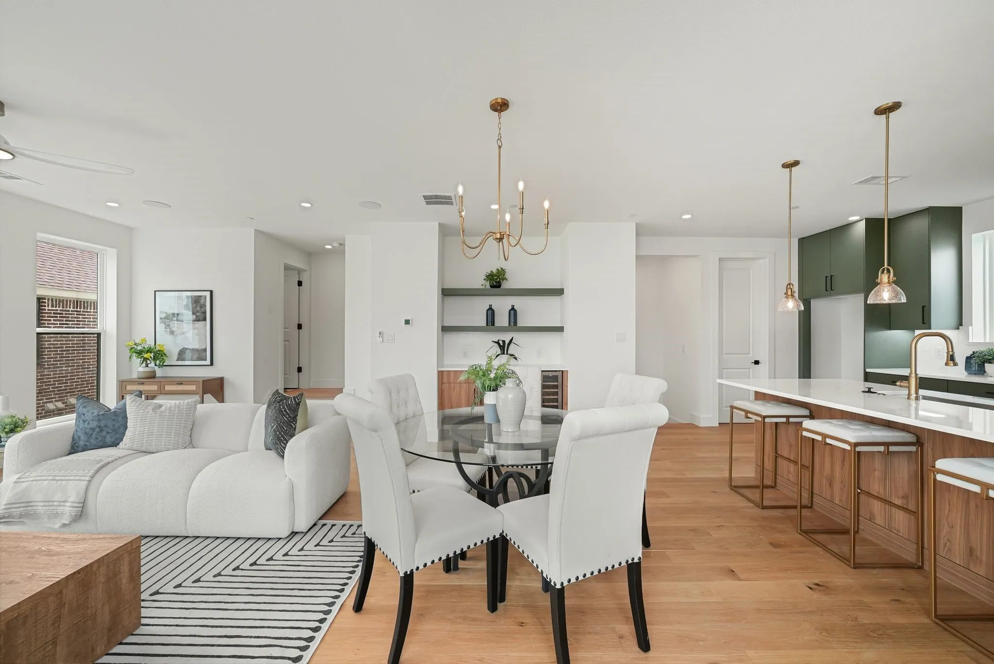 Spacious open-concept living area featuring light wood-finish flooring, recessed lighting, and white walls