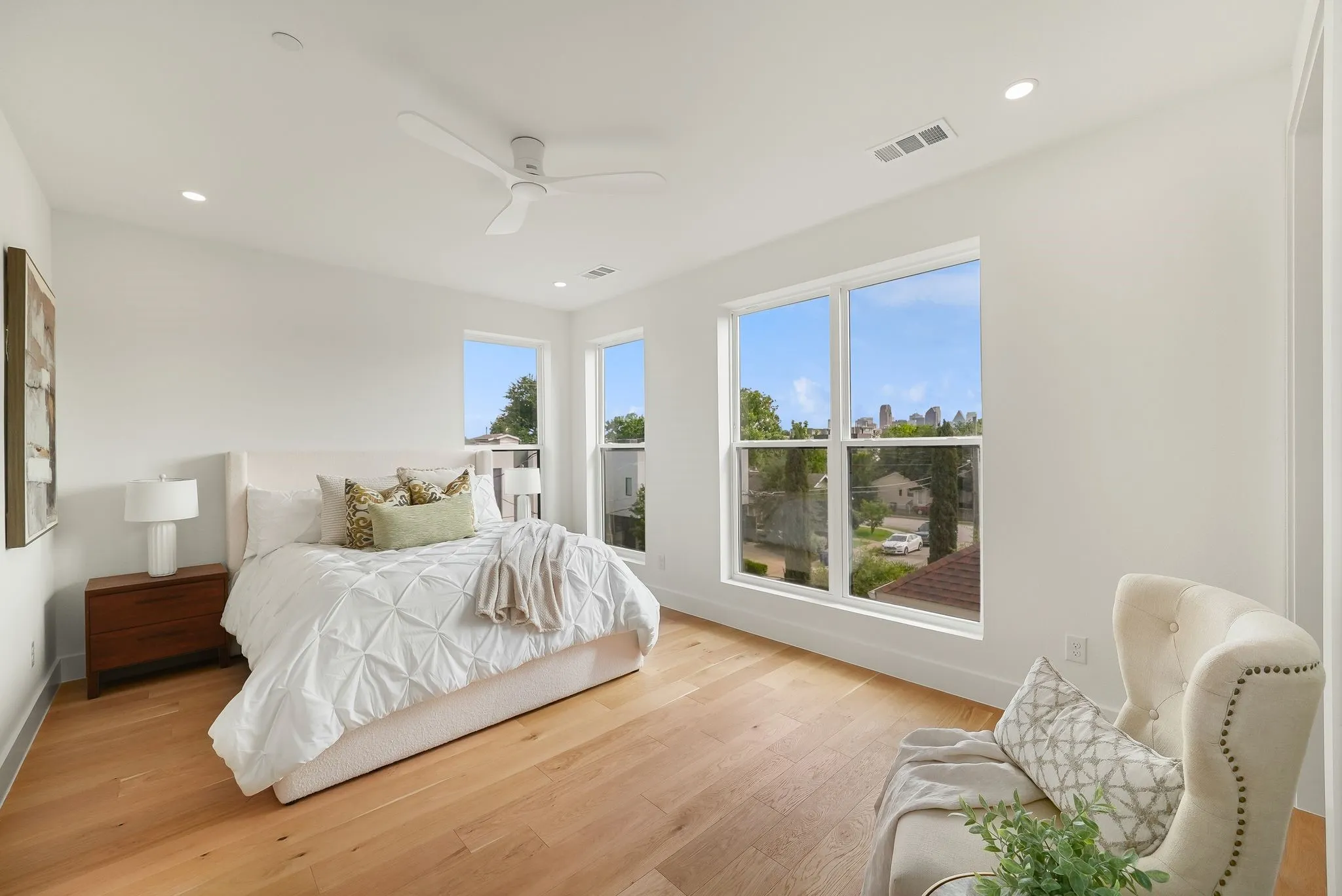 Bright bedroom featuring wide plank wood-finish flooring, recessed lighting, and a ceiling fan