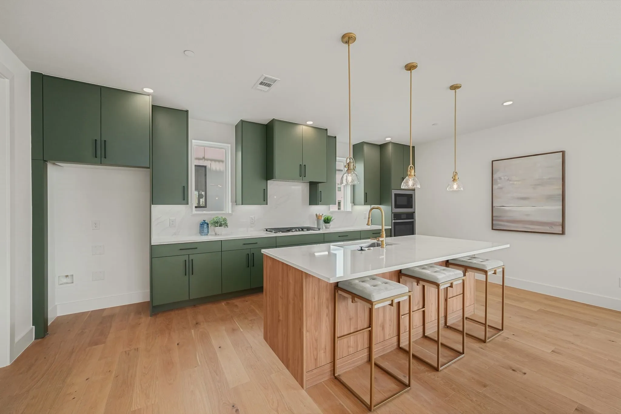 Contemporary kitchen featuring olive green cabinetry, light wood-finish flooring, and a large center island with seating