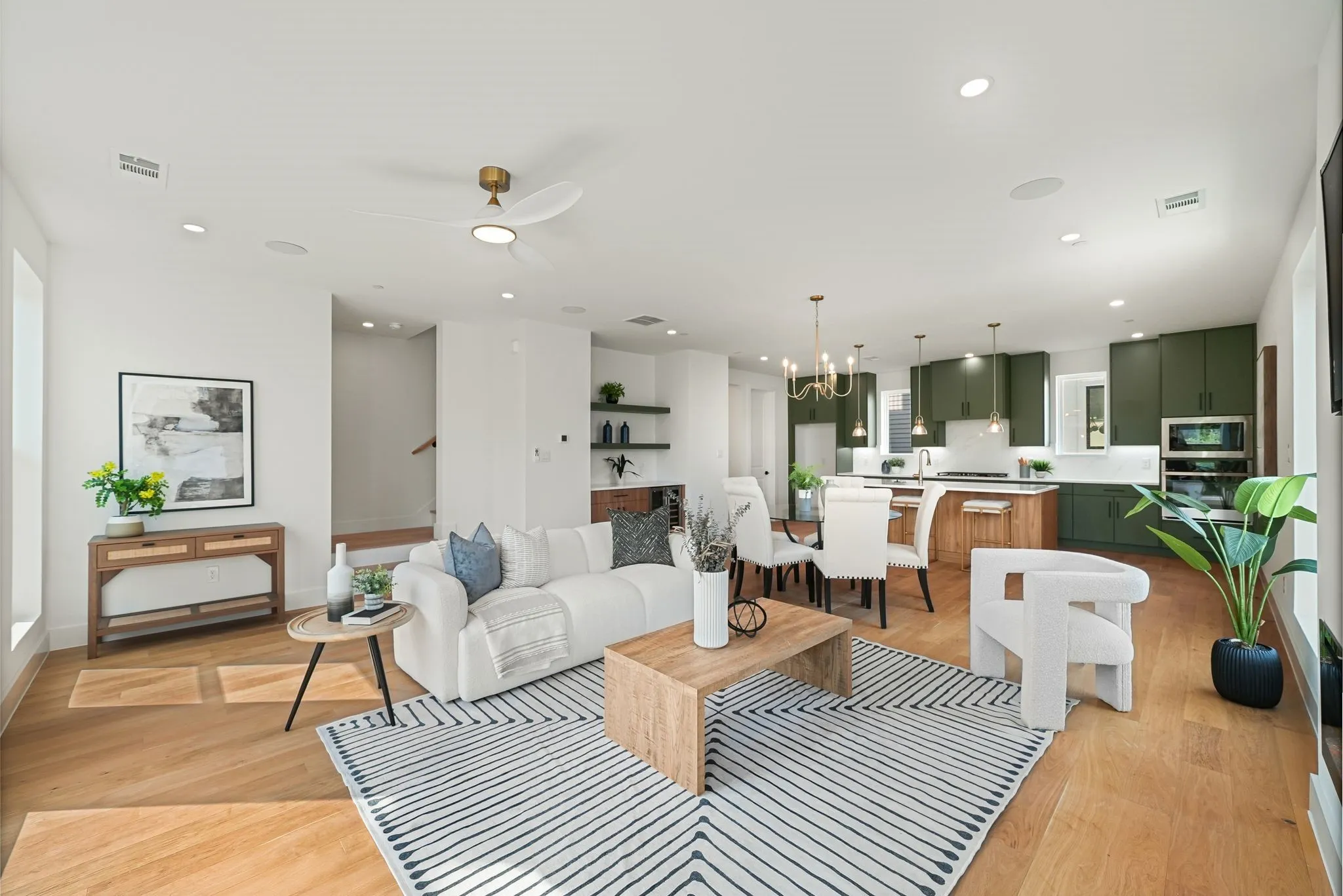 Open-concept living space featuring wood-finish flooring, recessed lighting, and a modern ceiling fan