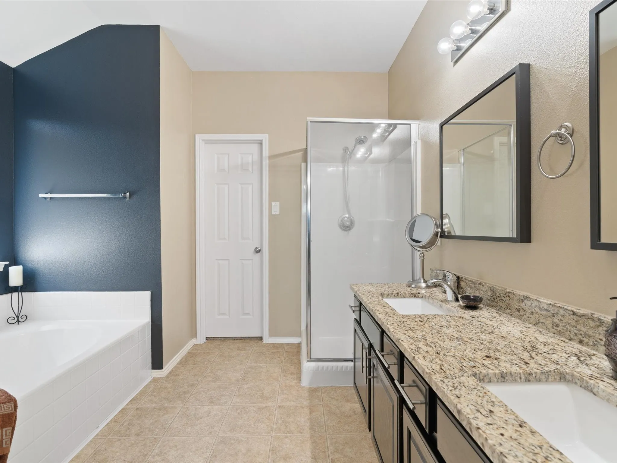 Bathroom featuring separate shower and tub, tile patterned floors, and double sink vanity