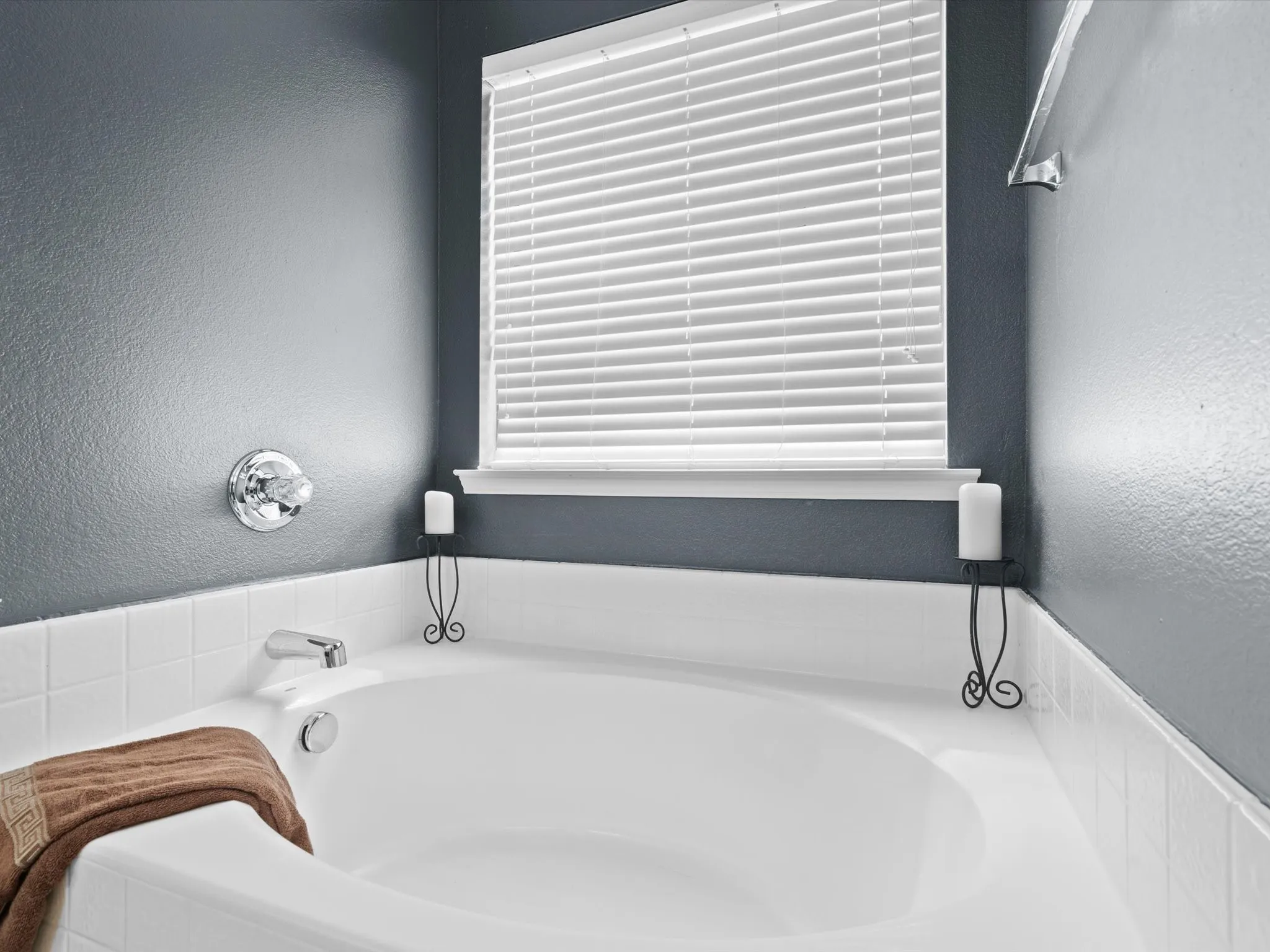 Bathroom with tiled tub and plenty of natural light