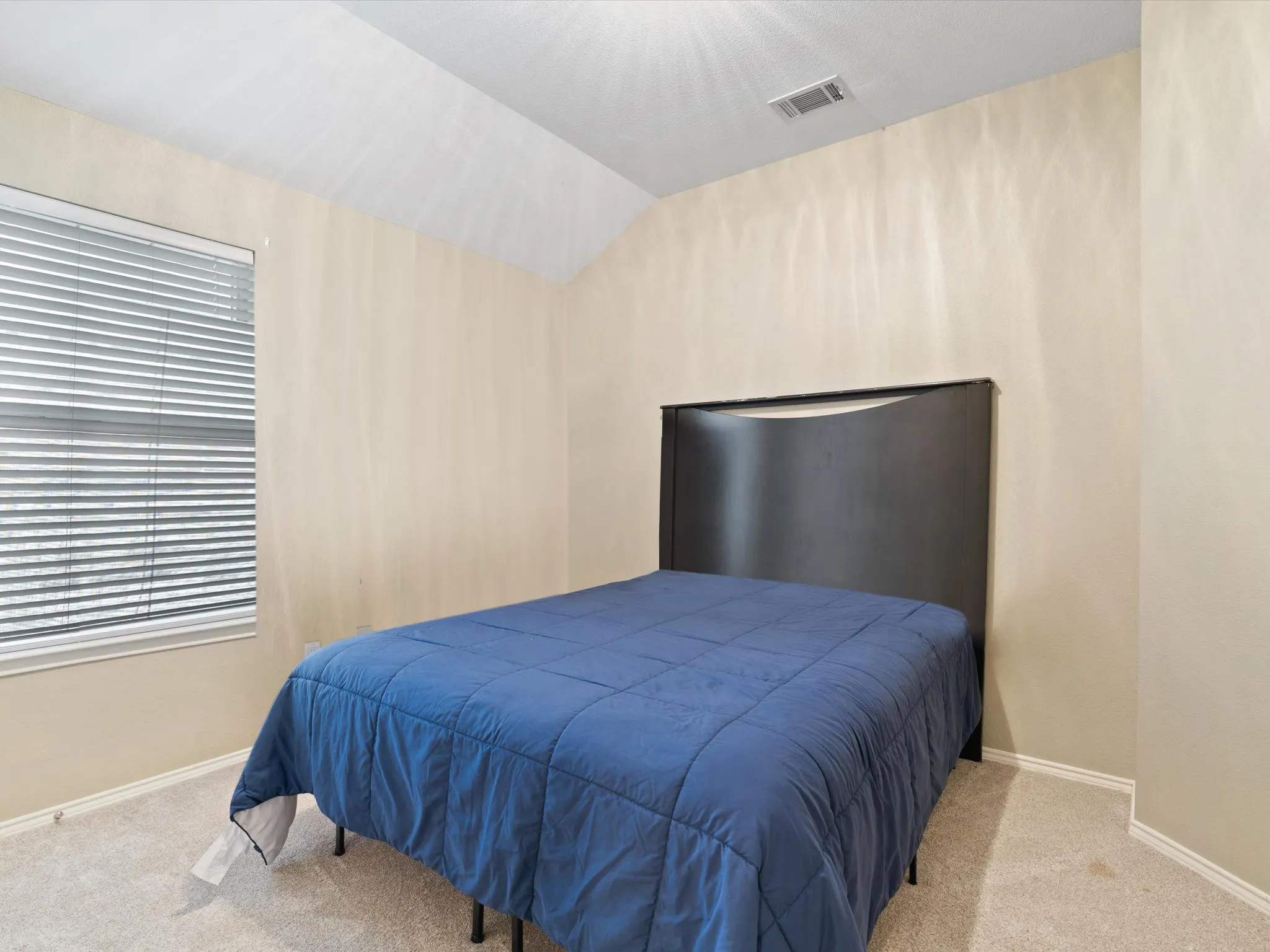 Bedroom with lofted ceiling and carpet floors