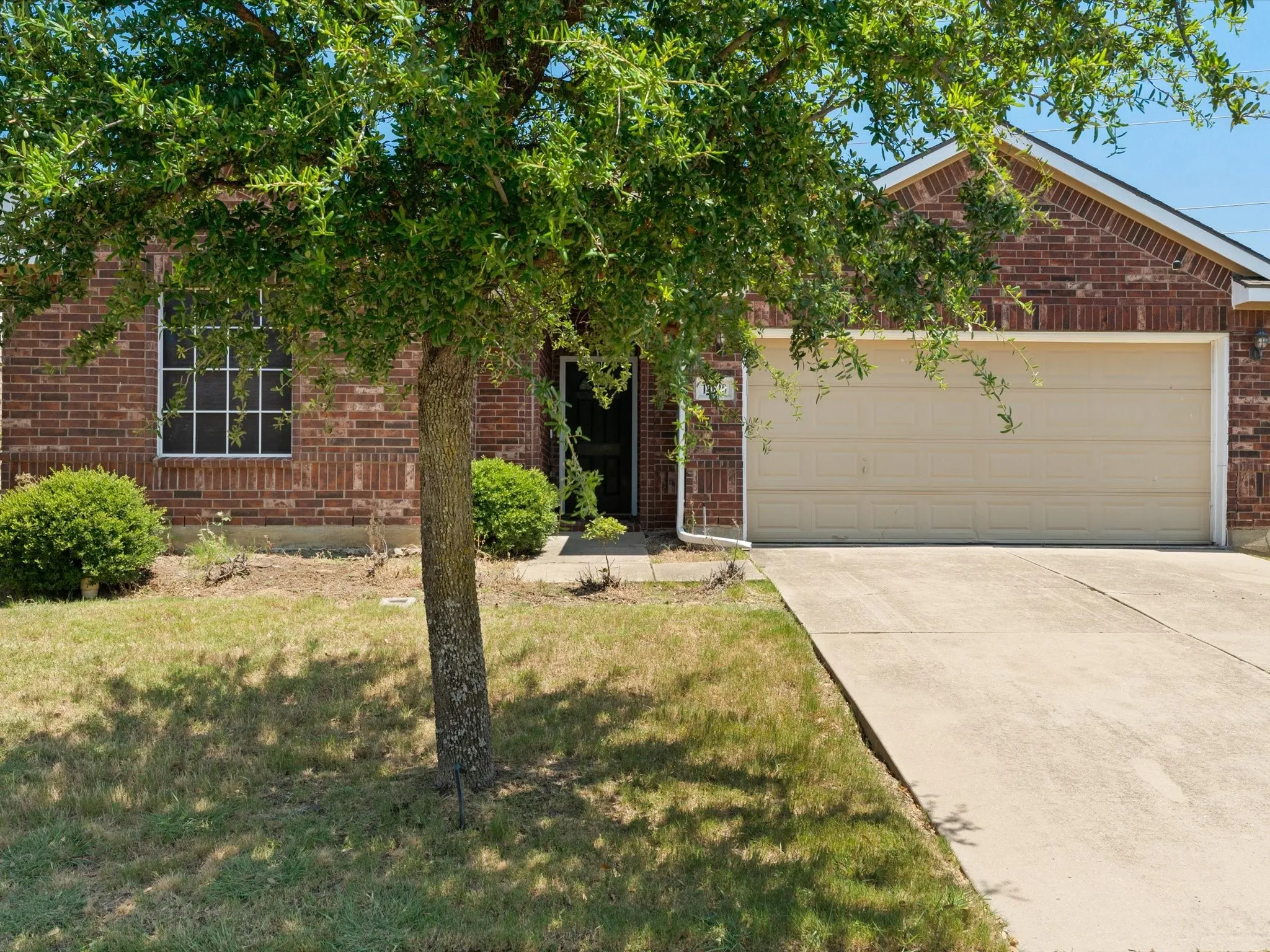 View of front facade featuring a garage and a front yard