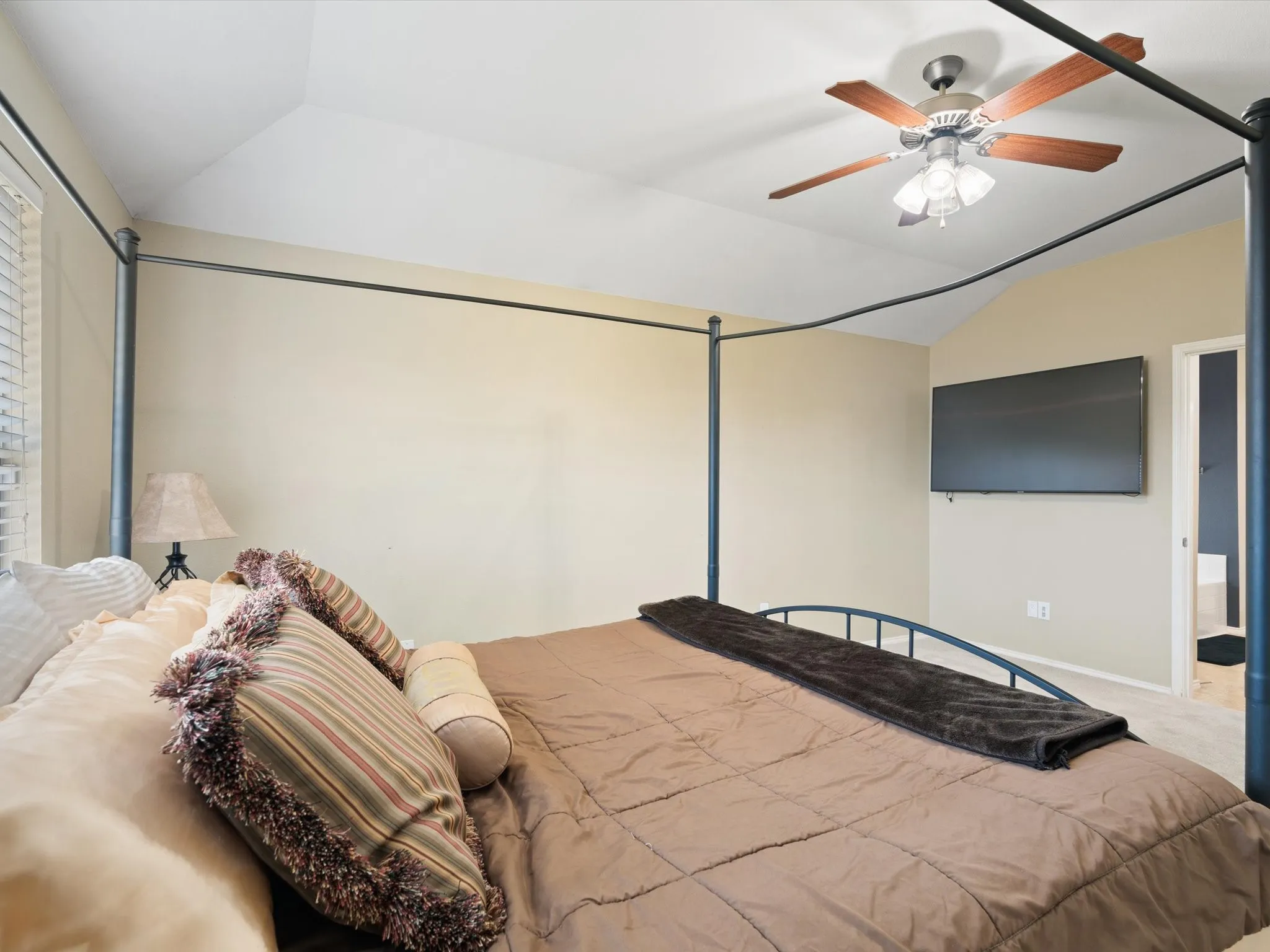Bedroom featuring carpet flooring, lofted ceiling, and ceiling fan