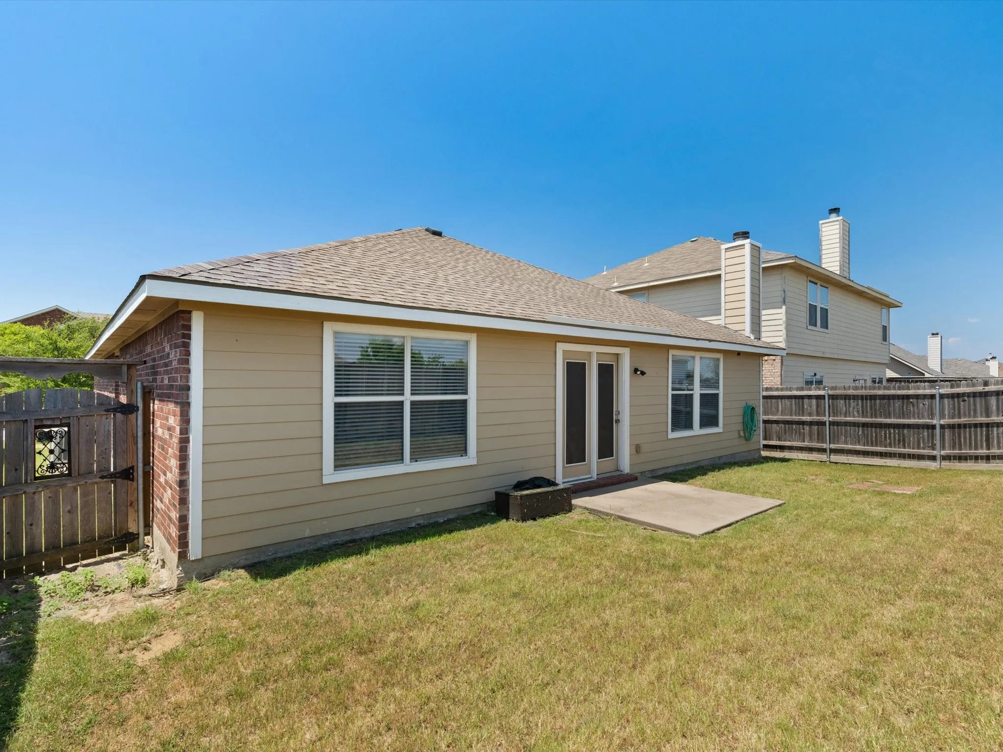 Rear view of property with a lawn and a patio area