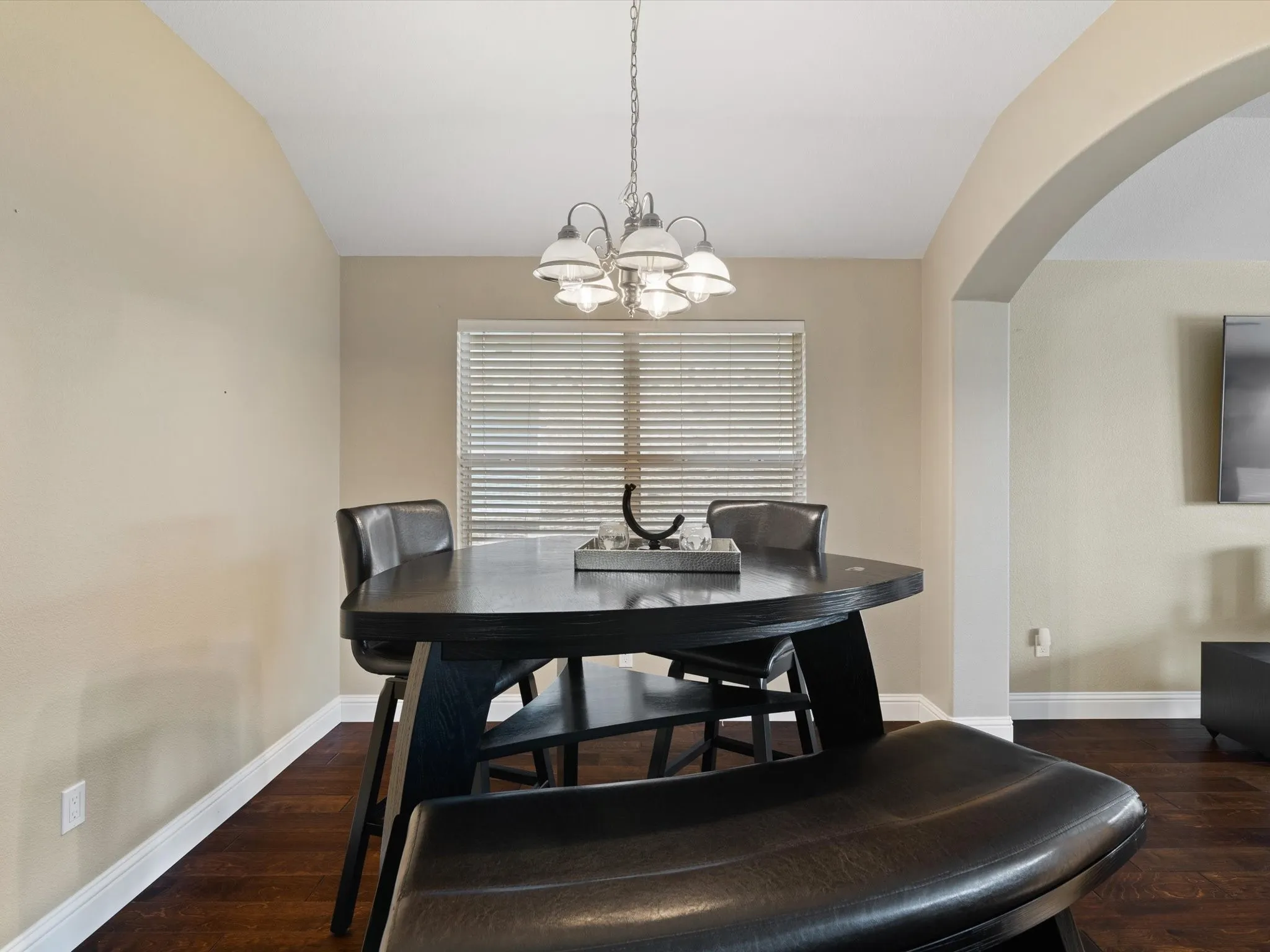 Dining room with an inviting chandelier, dark hardwood / wood-style floors, and lofted ceiling