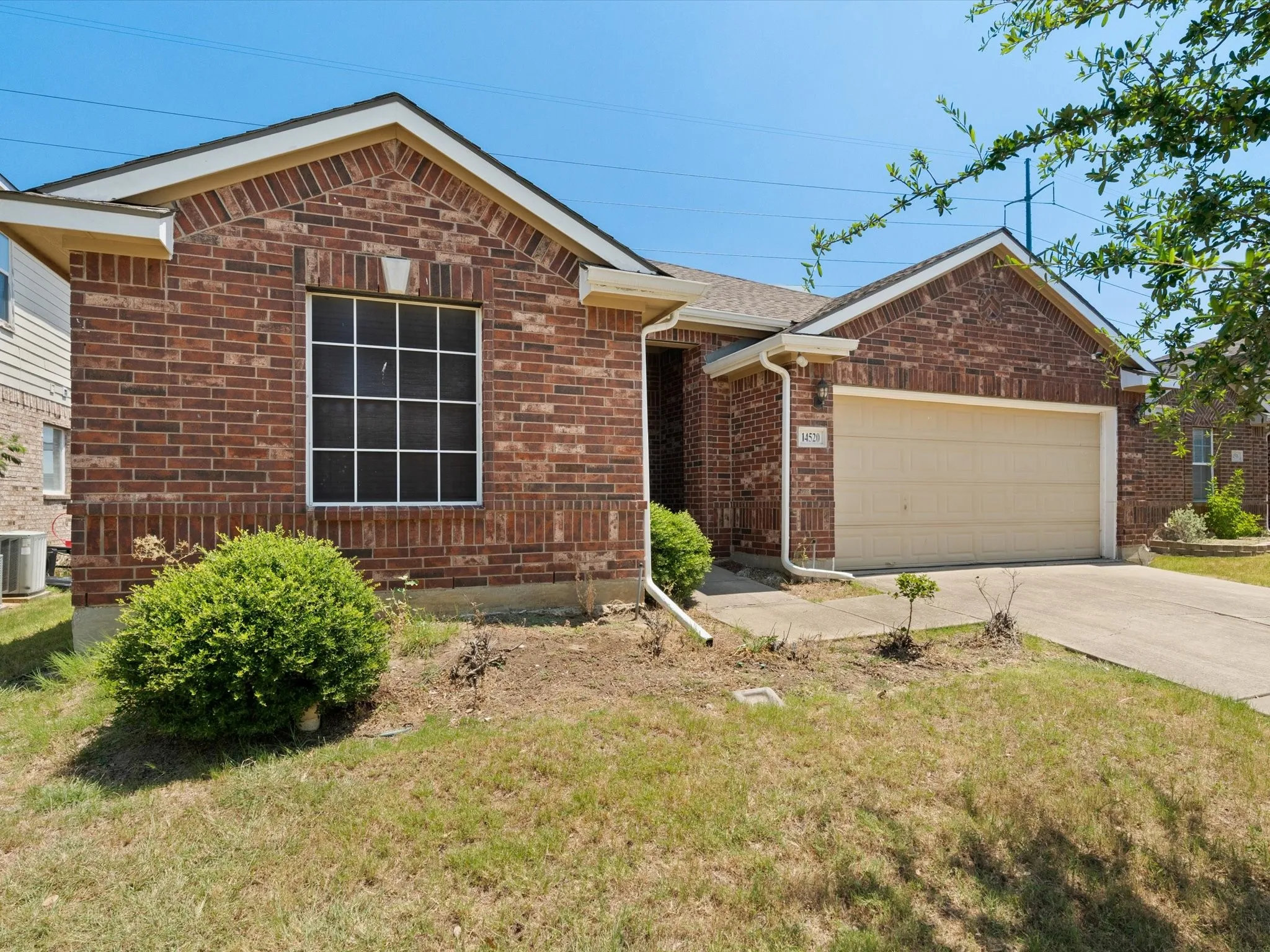 View of front of home featuring a garage, central AC, and a front lawn