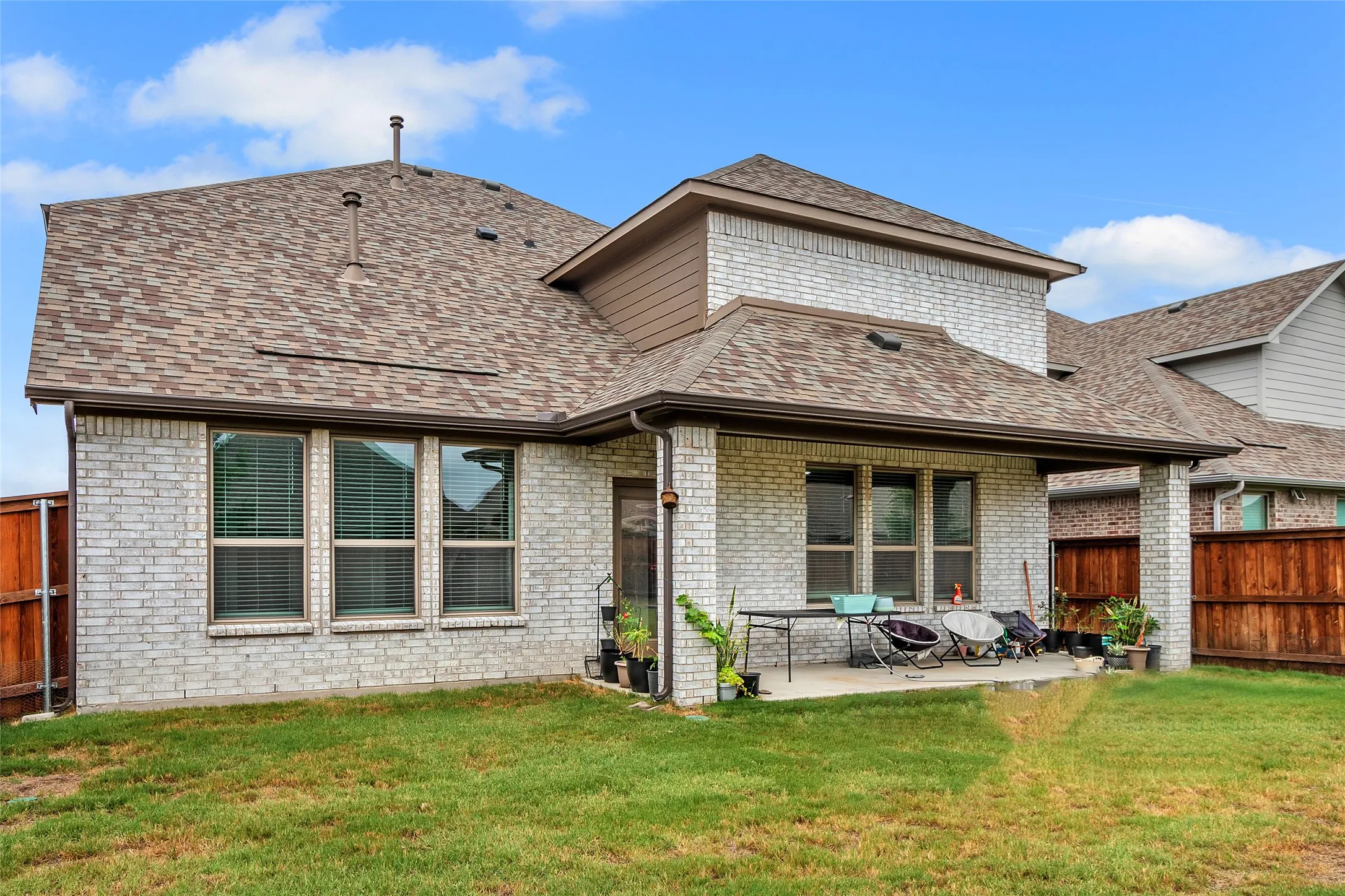 Back of house with a yard and a patio